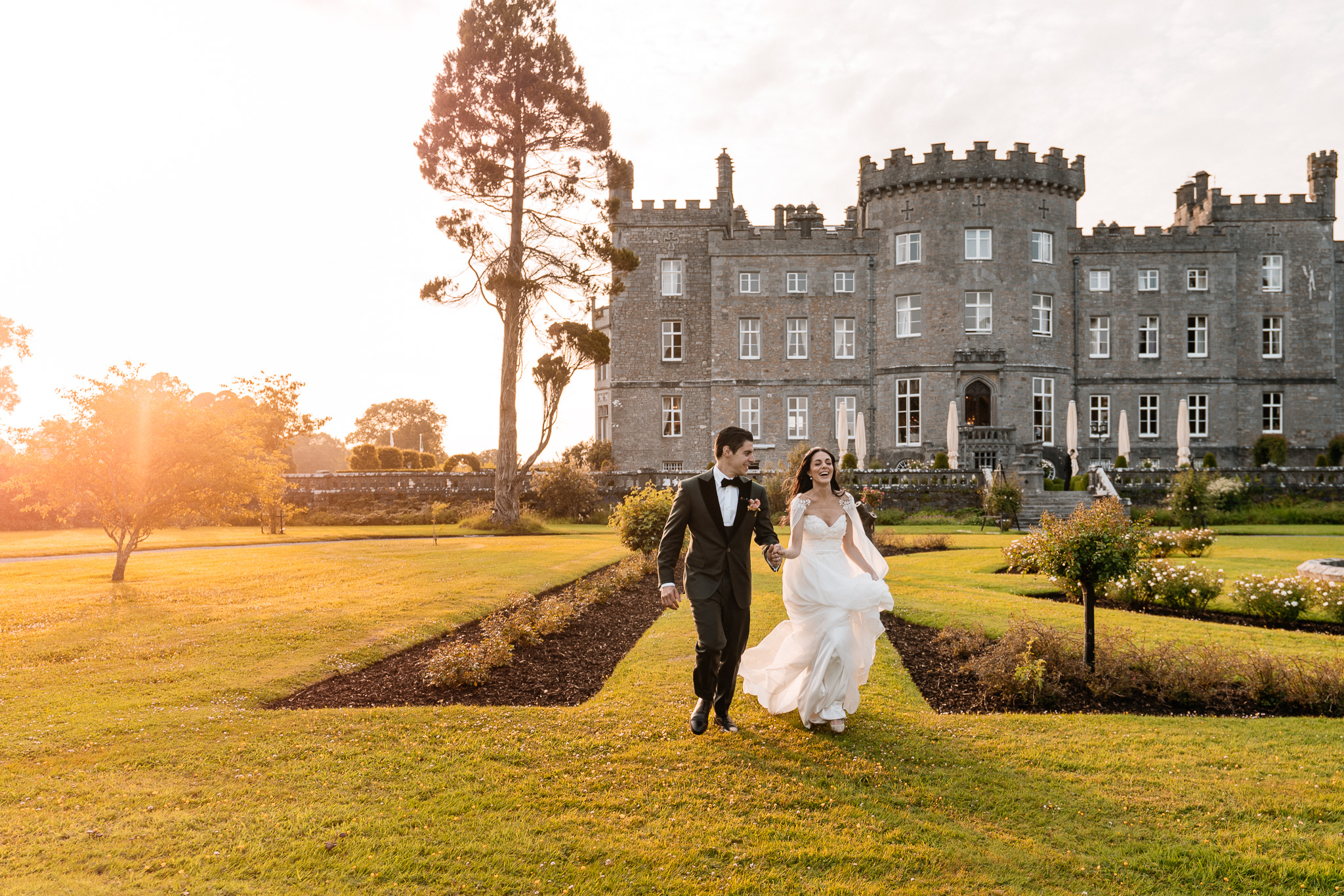 Bride and groom walking at sunset in front of Markree Castle in Sligo, Ireland