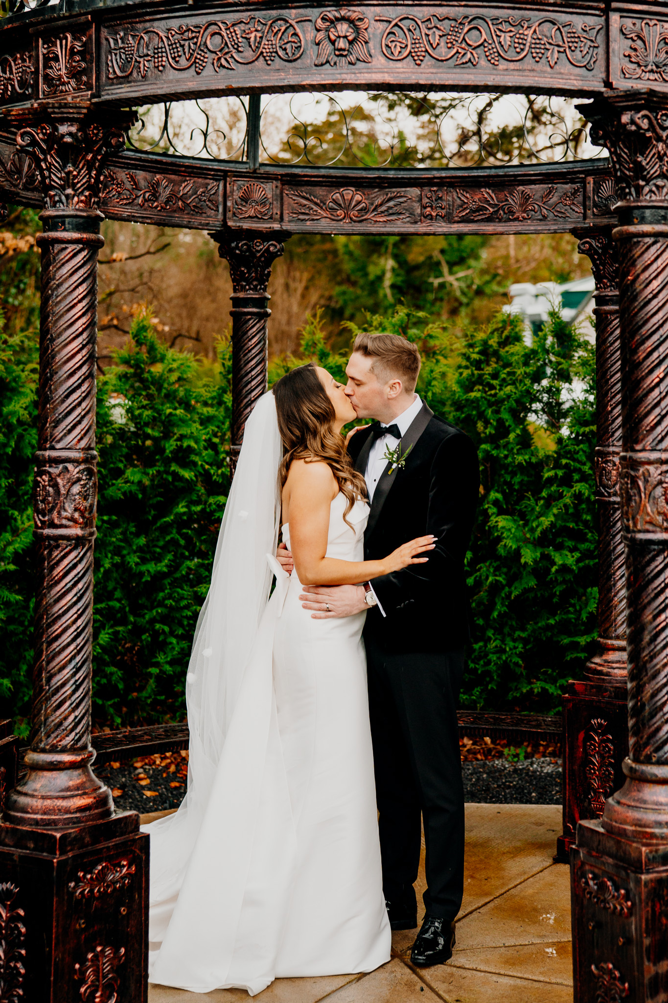 Bride and groom kissing beneath the garden arch at Markree Castle