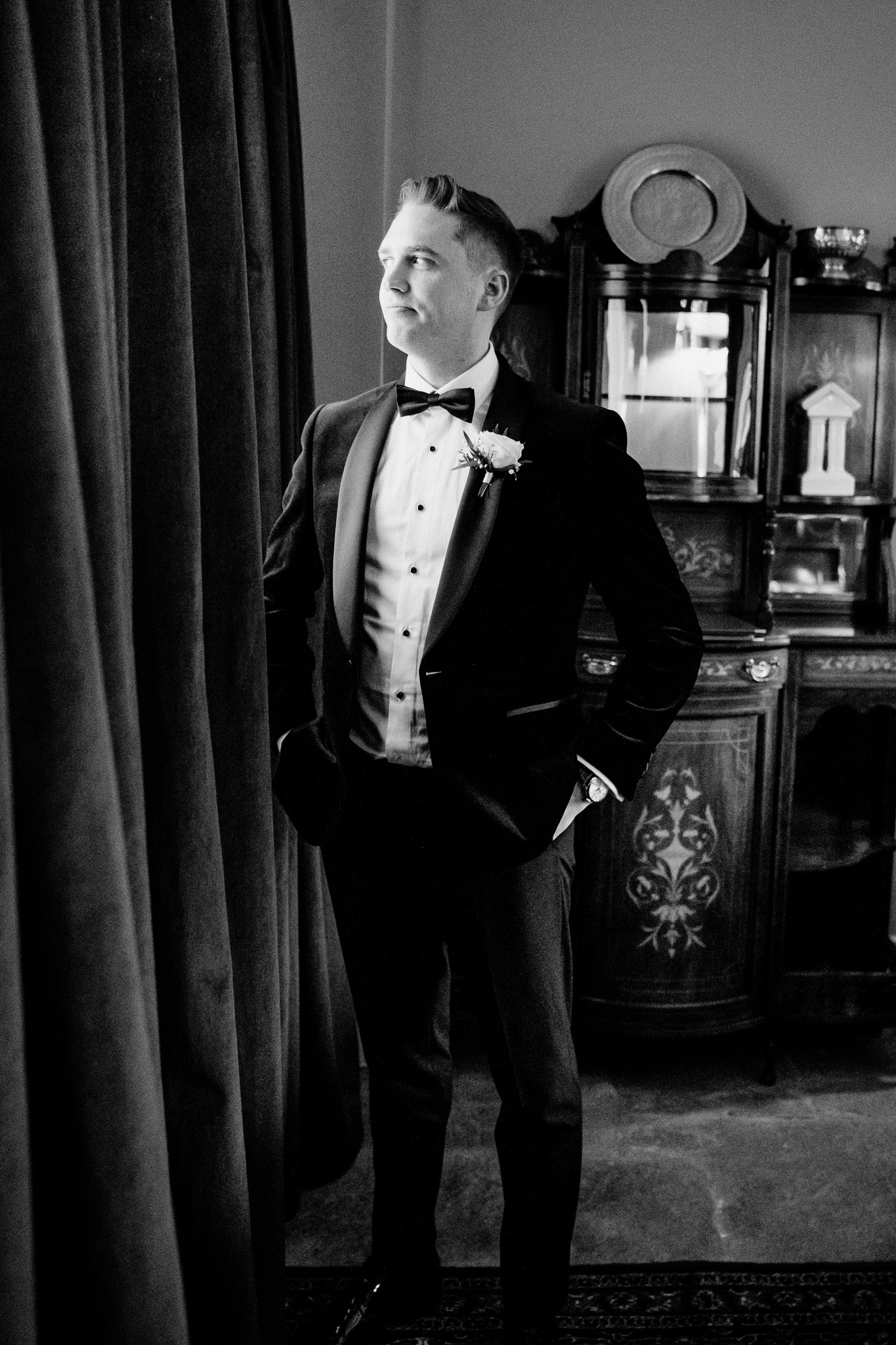 Groom standing by a window before his wedding ceremony in Sligo