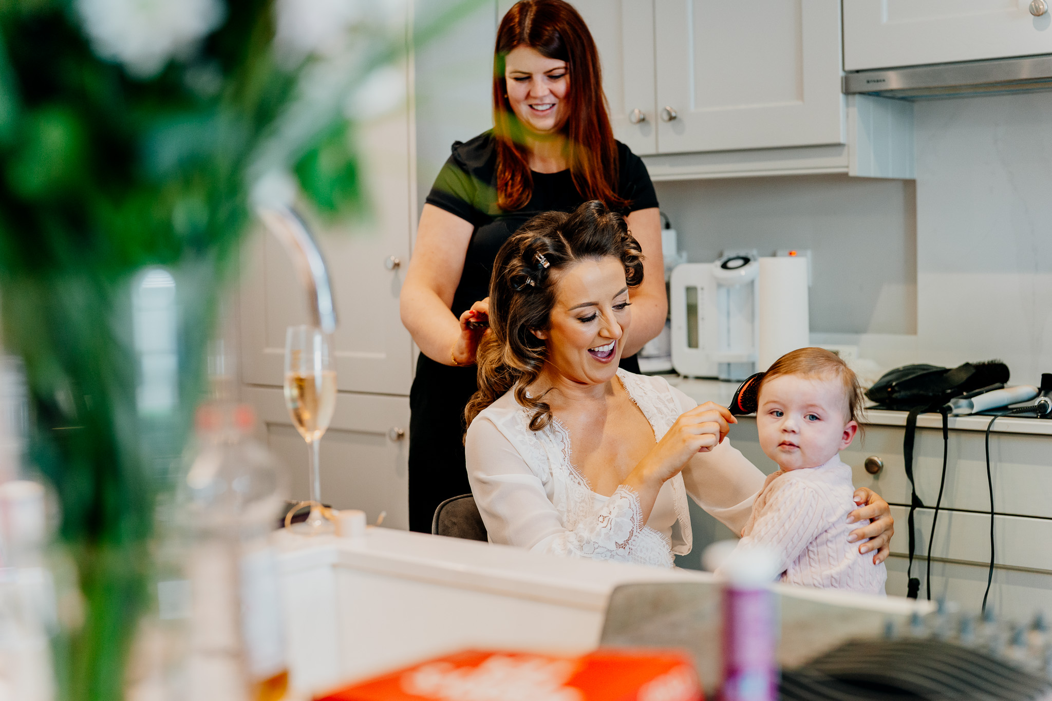 Young wedding guest having her hair prepared on the wedding morning