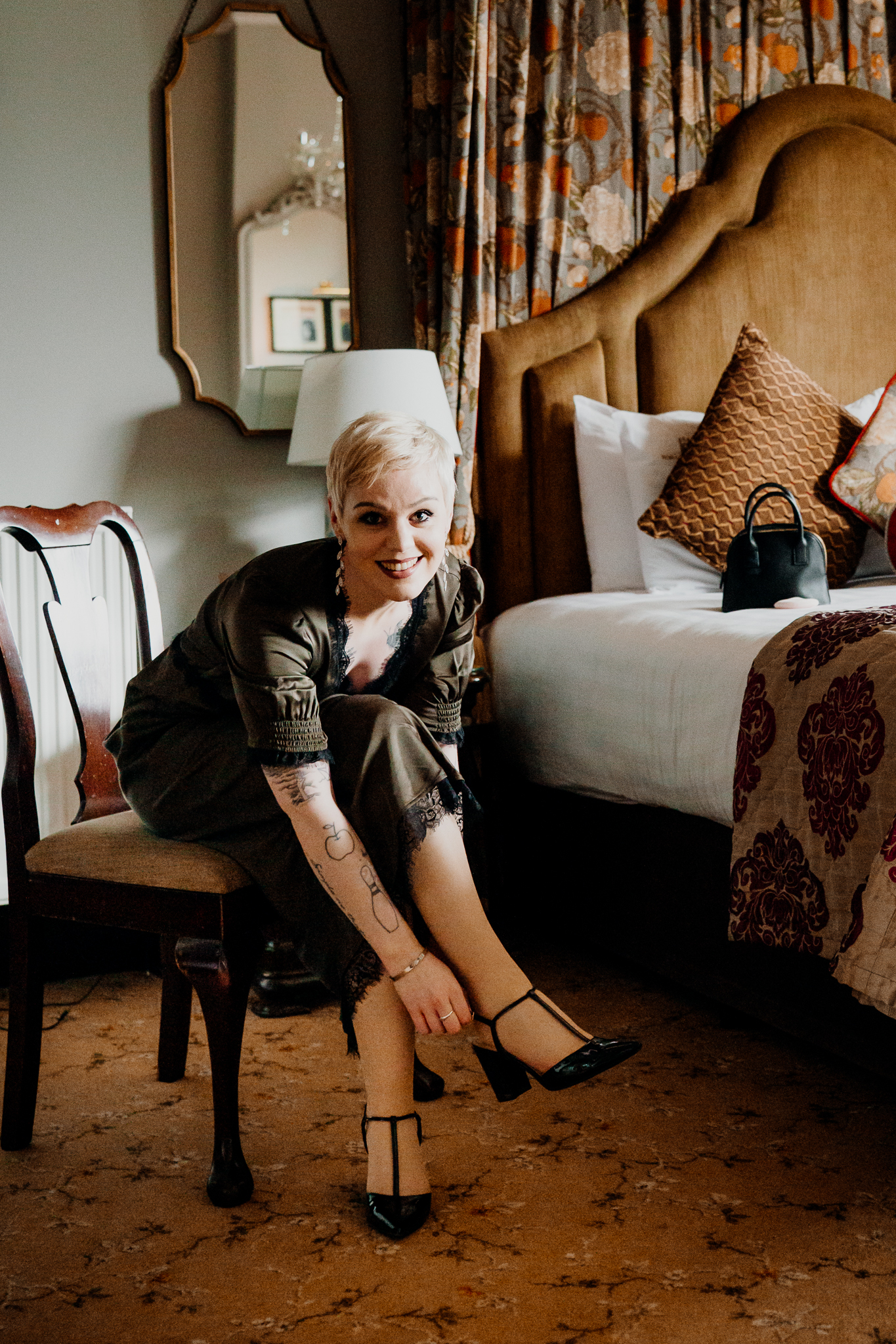 Meagan sitting beside the bed during wedding preparations in the Johnny Cash Room at Markree Castle