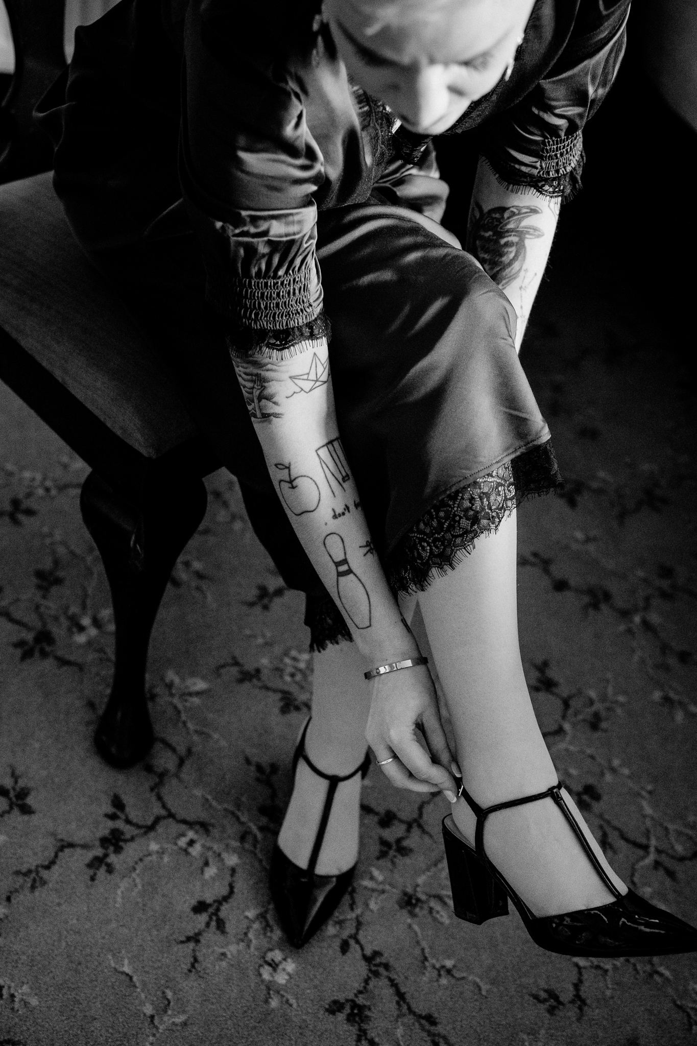 Black and white close-up of Meagan fastening her shoes during wedding preparations at Markree Castle