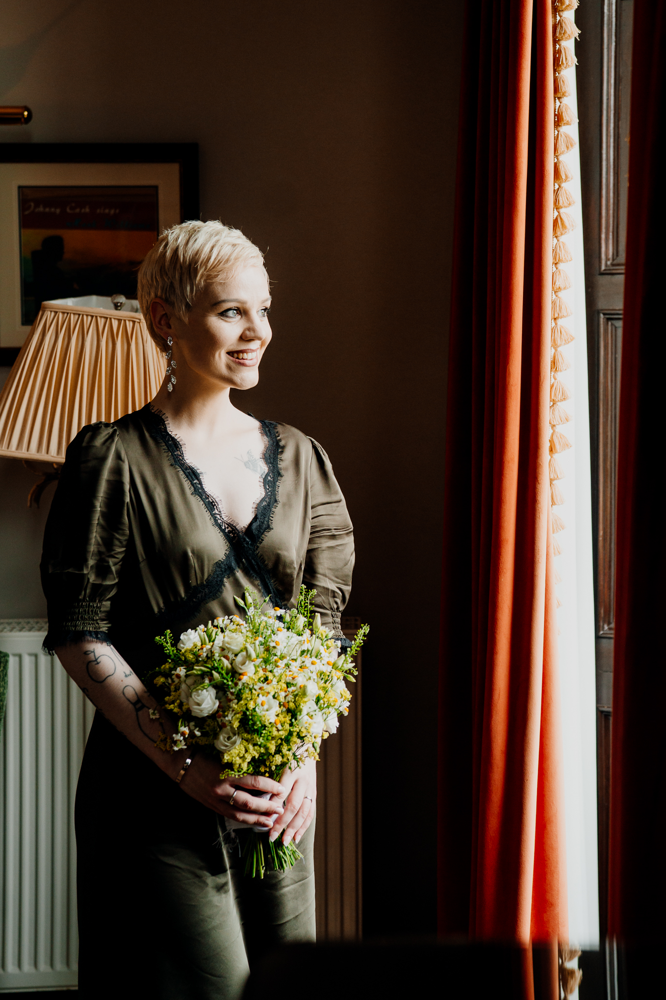 Meagan holding her wedding bouquet beside a window in the Johnny Cash Room at Markree Castle