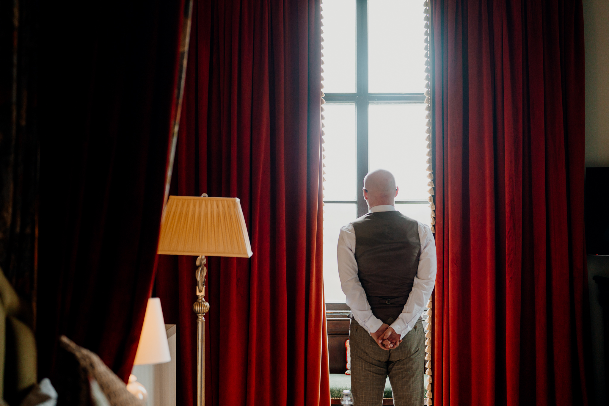 Groom standing beside a window during wedding preparations in the Johnny Cash Room at Markree Castle