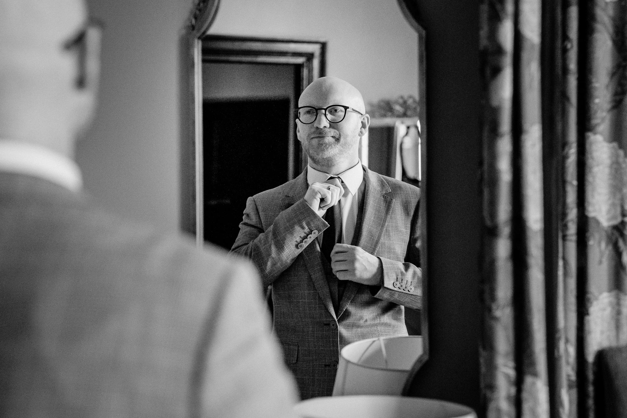 Black and white portrait of the groom reflected in a mirror while getting ready at Markree Castle