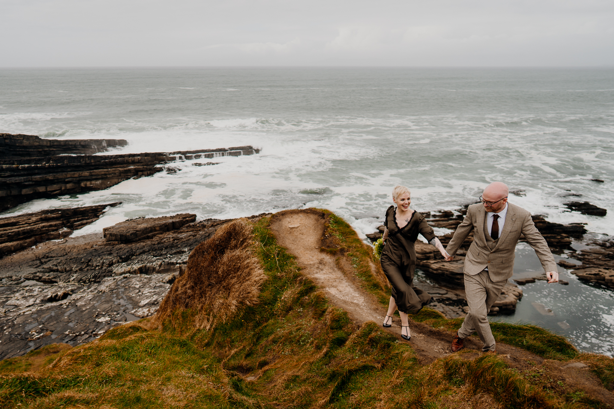Intimate wedding couple standing on Mullaghmore Head above the rocky Atlantic coastline in Sligo