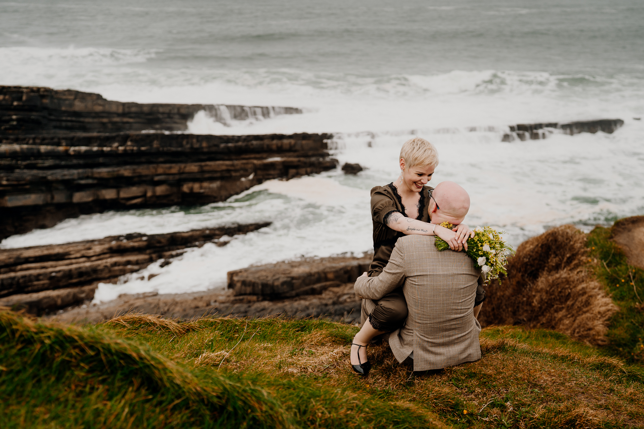 Newlyweds sitting together overlooking the Atlantic Ocean at Mullaghmore Head Sligo