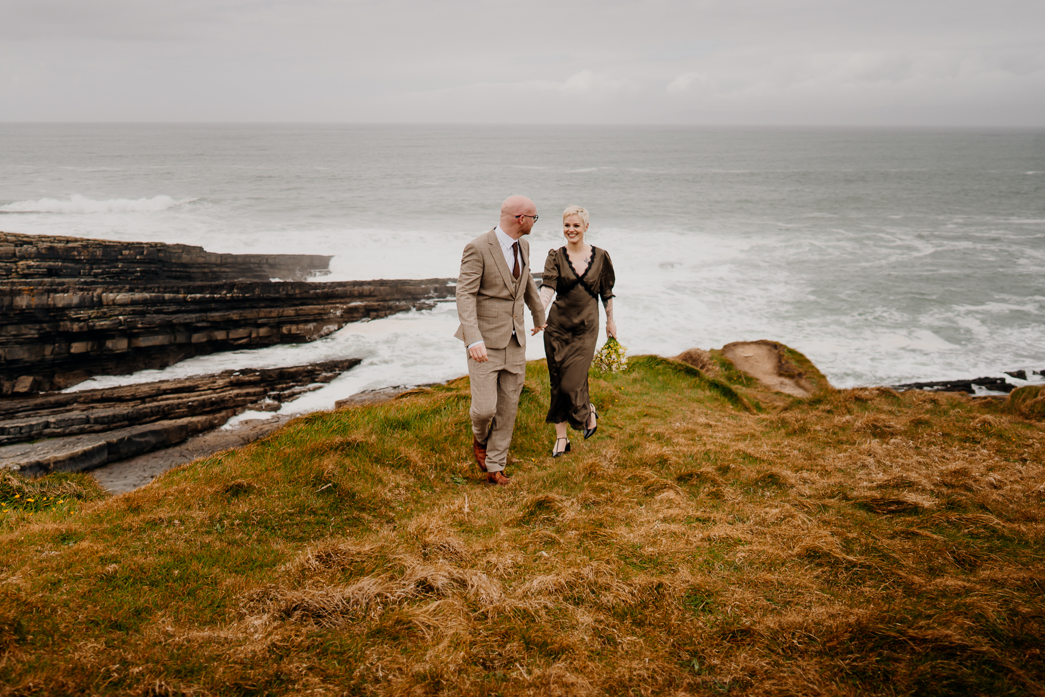 Wedding couple standing together above the rugged cliffs and Atlantic waves at Mullaghmore Head