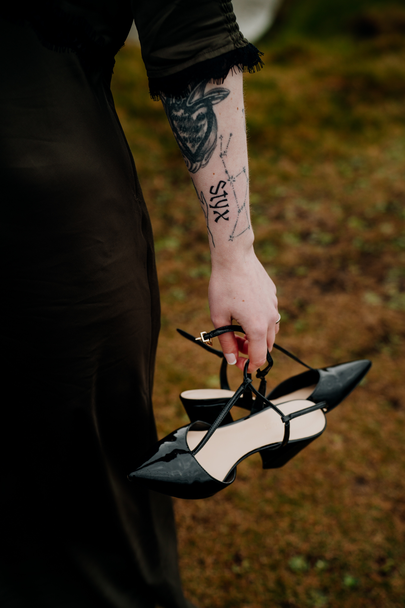 Bride carrying her wedding shoes during a coastal portrait session at Mullaghmore Head