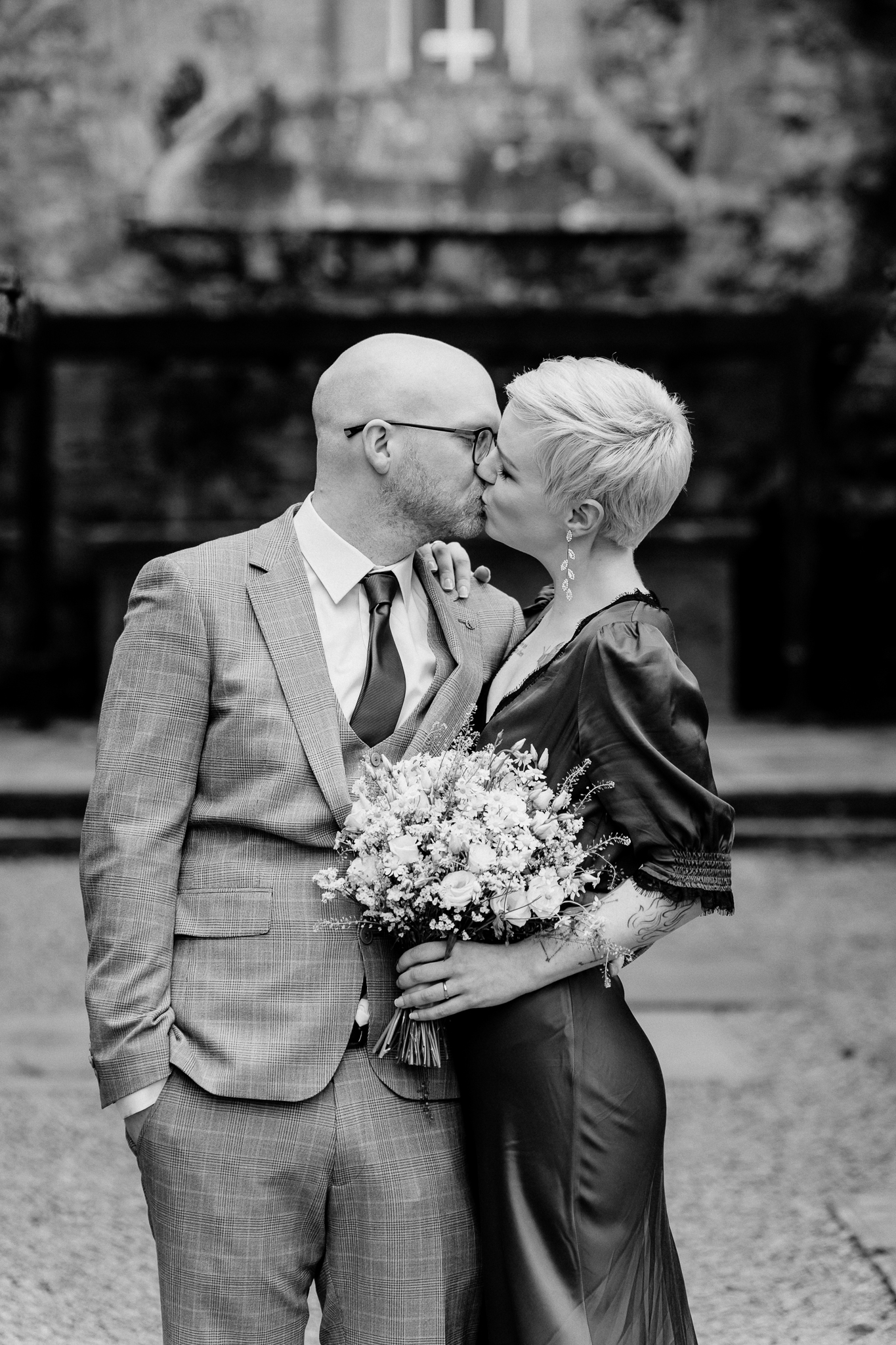 Black and white wedding photograph of a couple kissing at Sligo Abbey