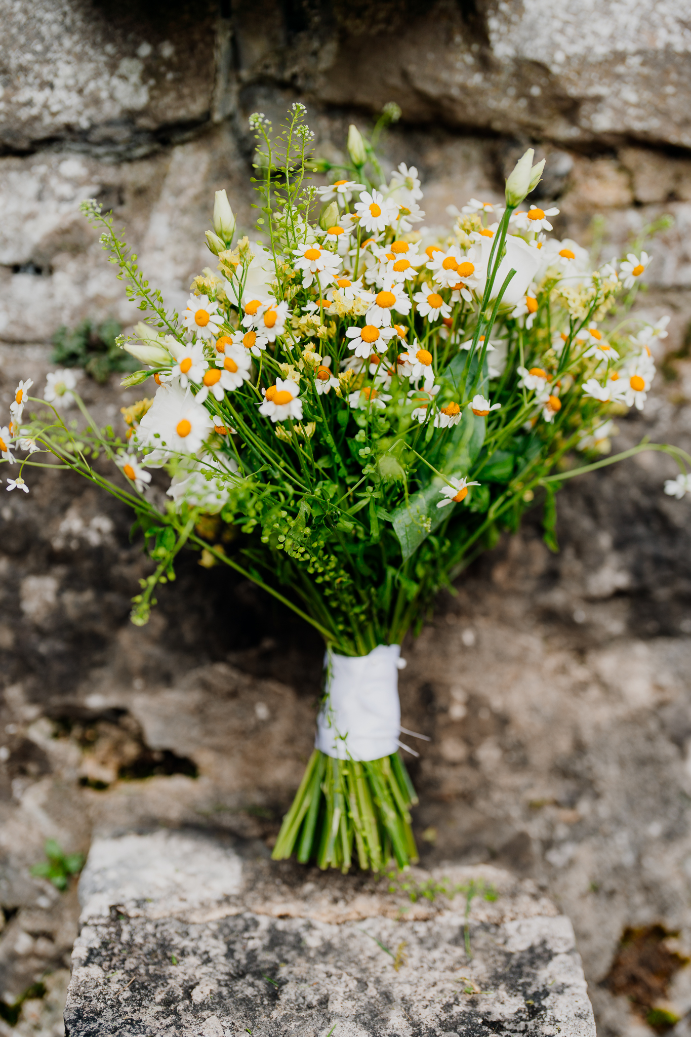 Colourful bridal bouquet photographed against the historic stone walls of Sligo Abbey