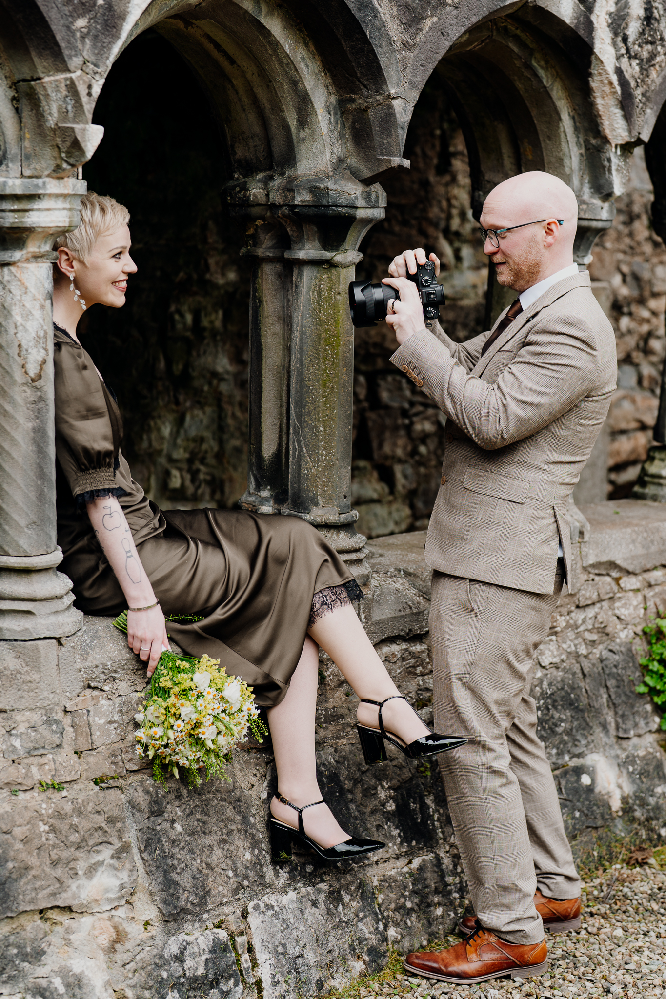 Wedding photographer taking a bridal portrait among the historic ruins of Sligo Abbey