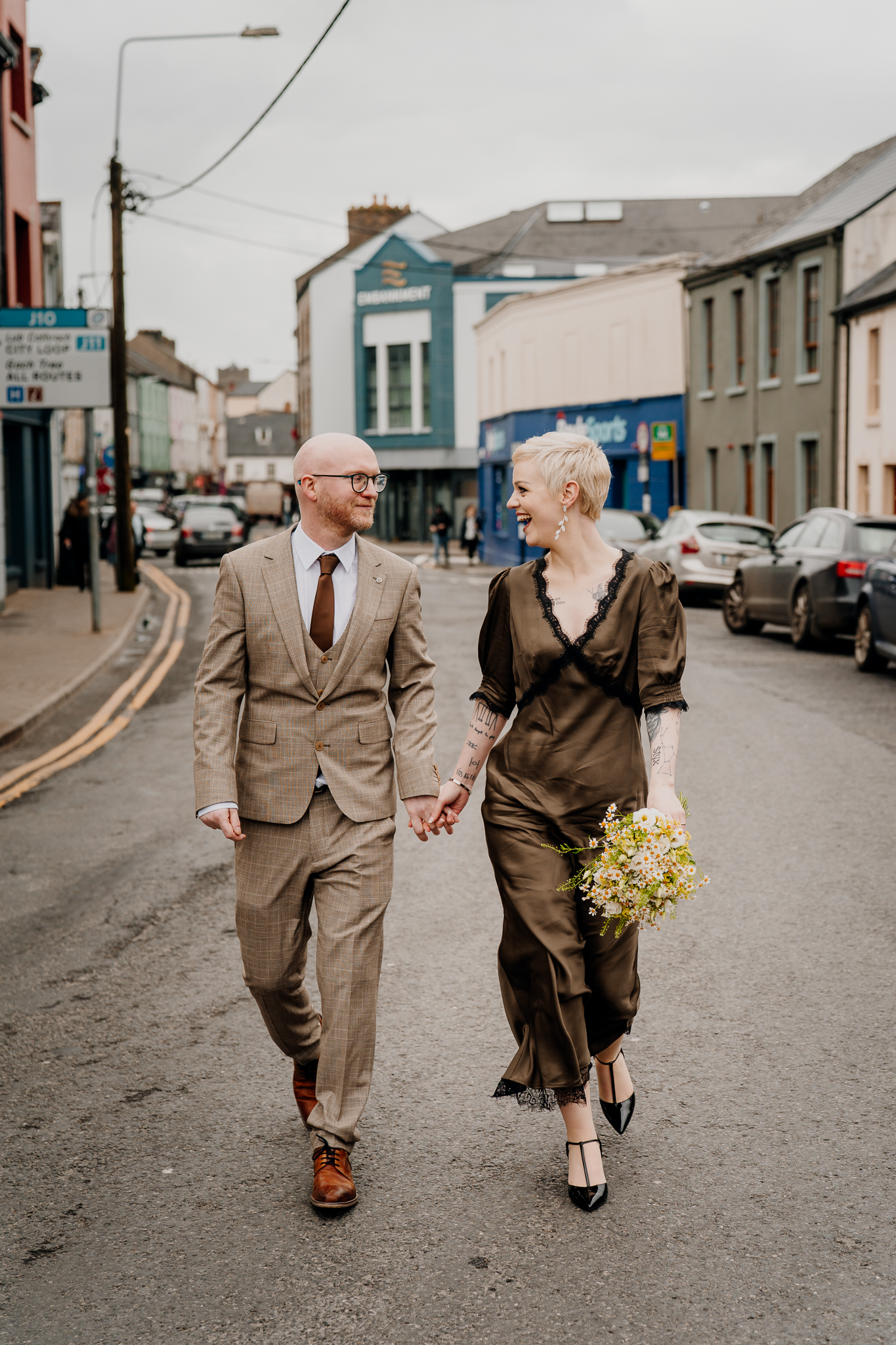 Newly married couple walking through Sligo town after wedding portraits at Sligo Abbey