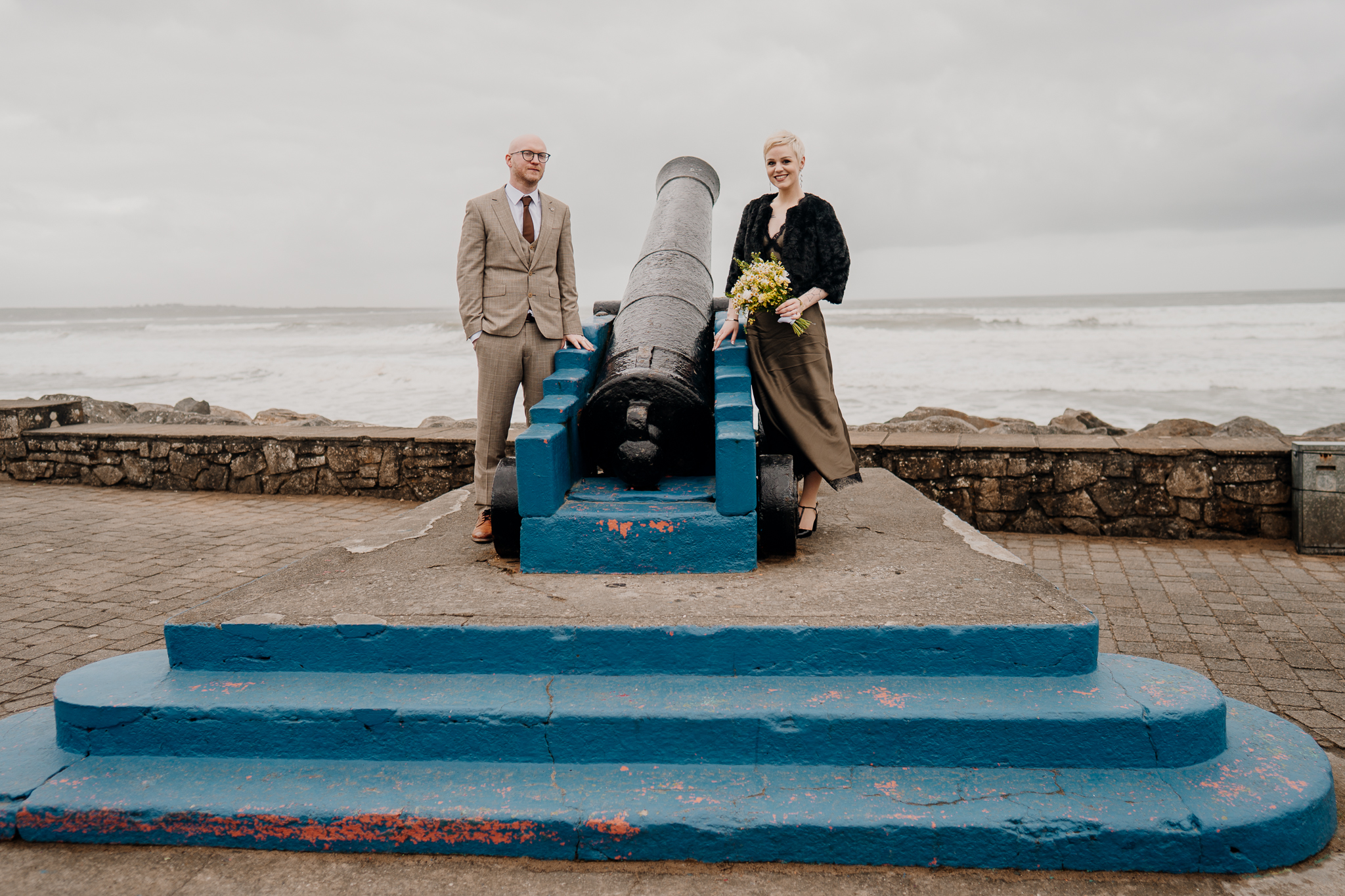 Newly married couple beside the historic Strandhill cannon on the seafront in County Sligo