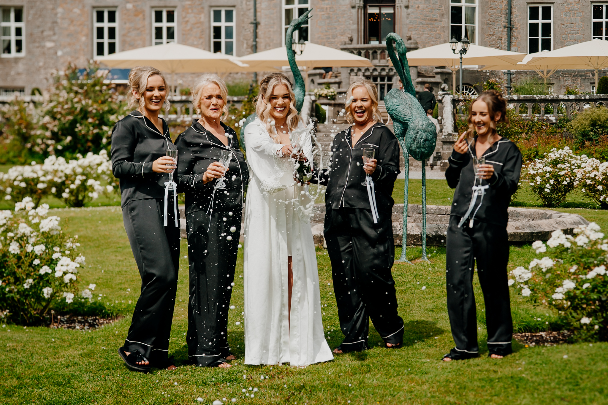 Bride and bridesmaids opening champagne in the gardens at Markree Castle