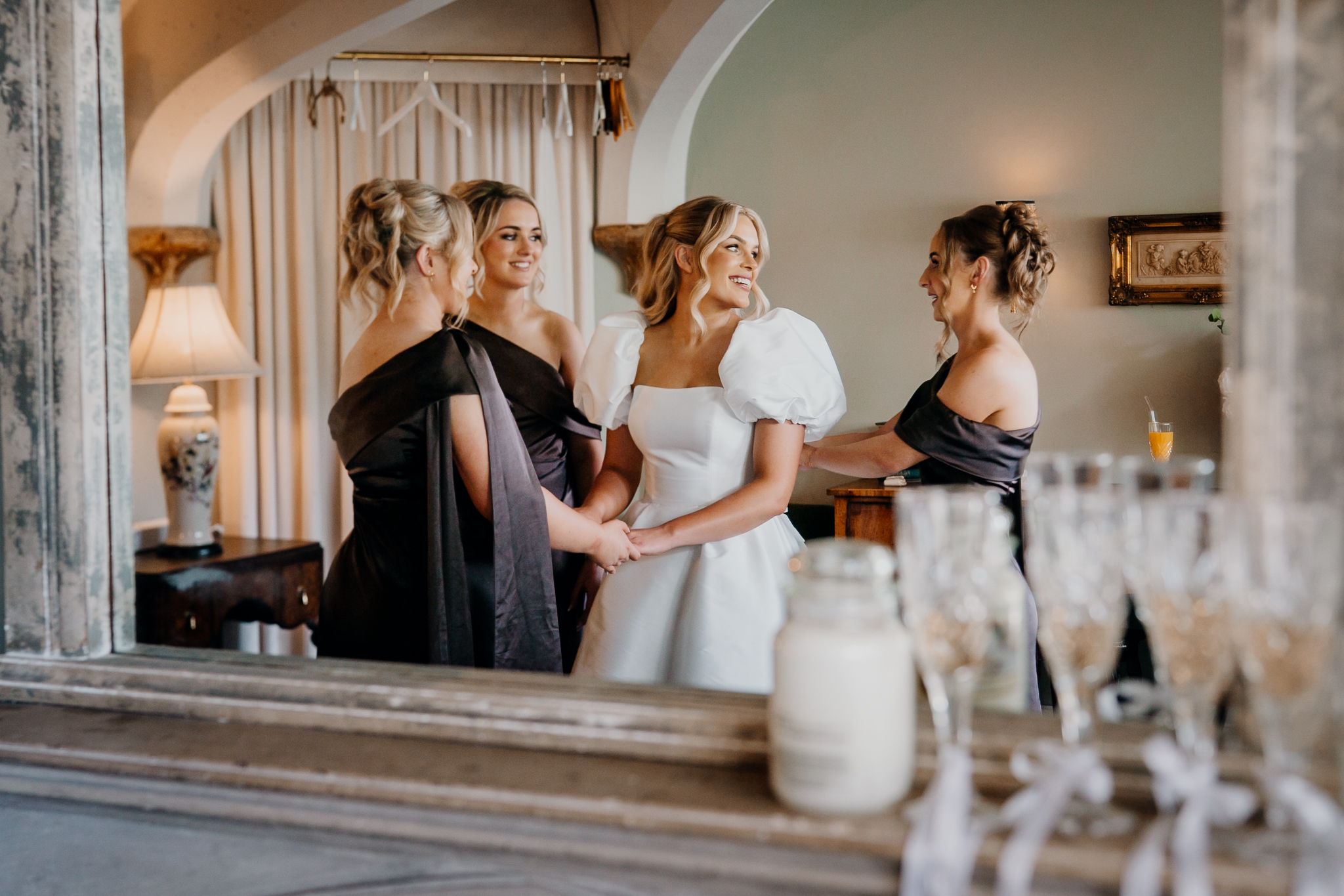Bridesmaid helping bride Caoimhe fasten her wedding dress at Markree Castle