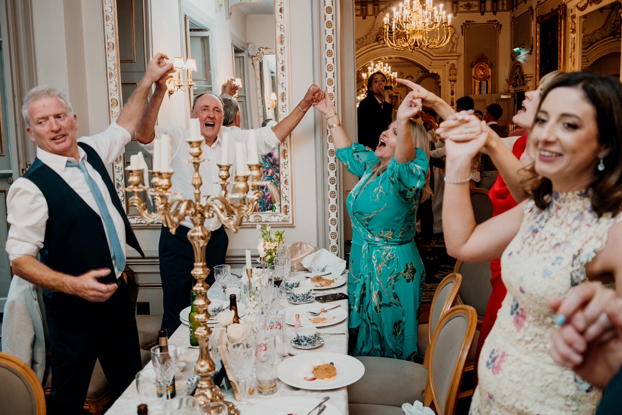 Wedding guests celebrating and waving napkins in the Dining Room at Markree Castle