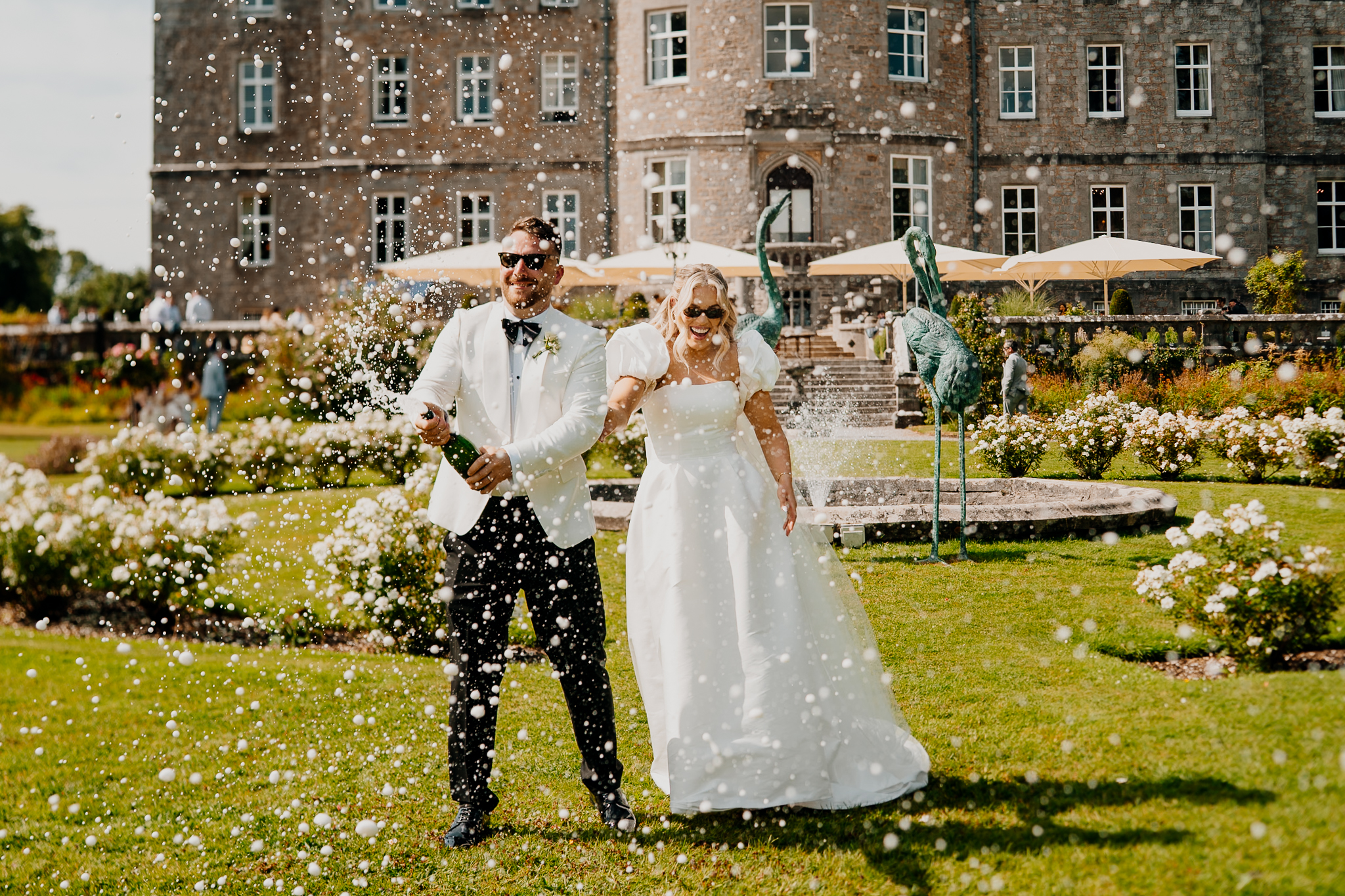 Caoimhe and Michael opening champagne beside the fountain at Markree Castle