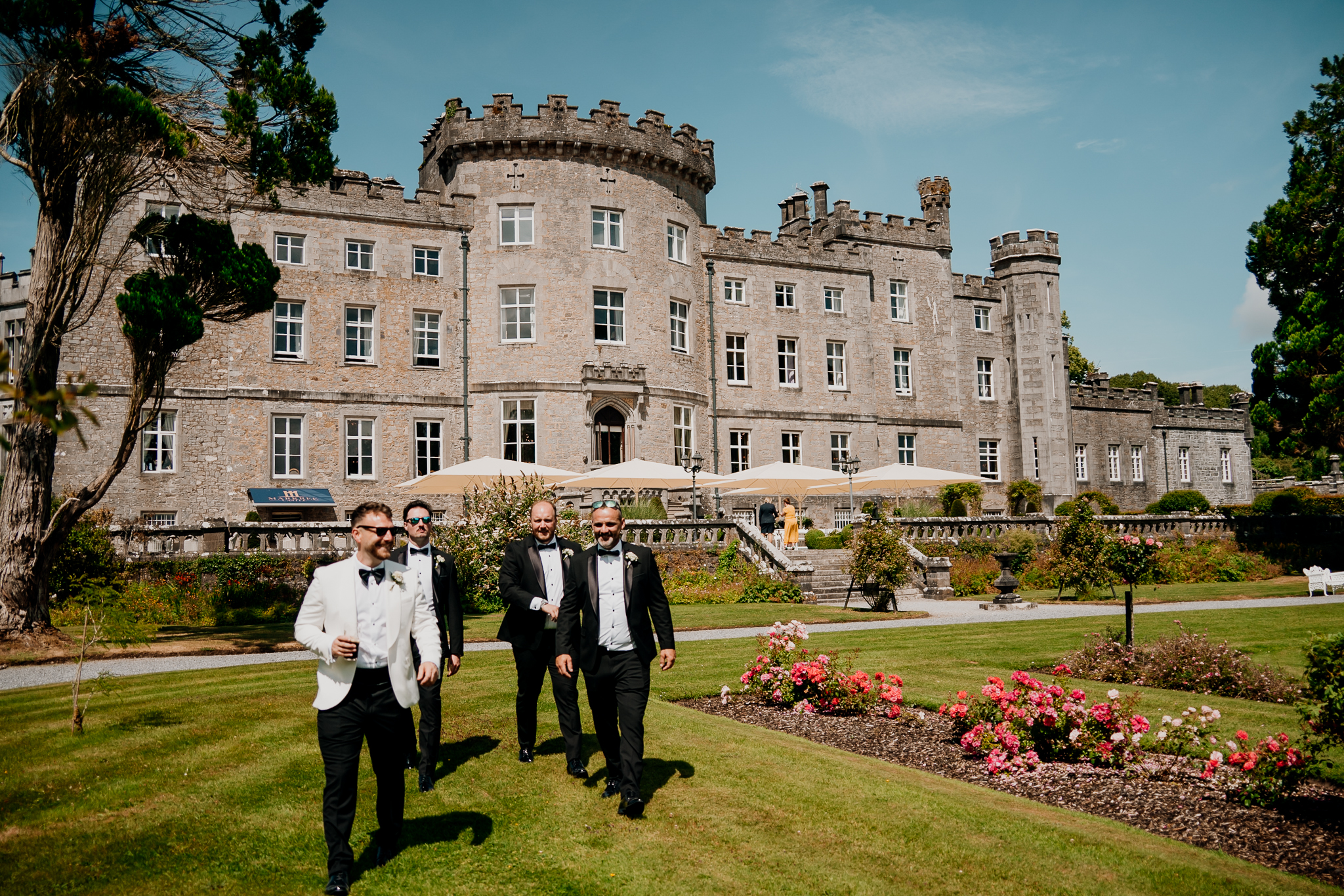Groom and groomsmen walking in front of Markree Castle on the wedding day