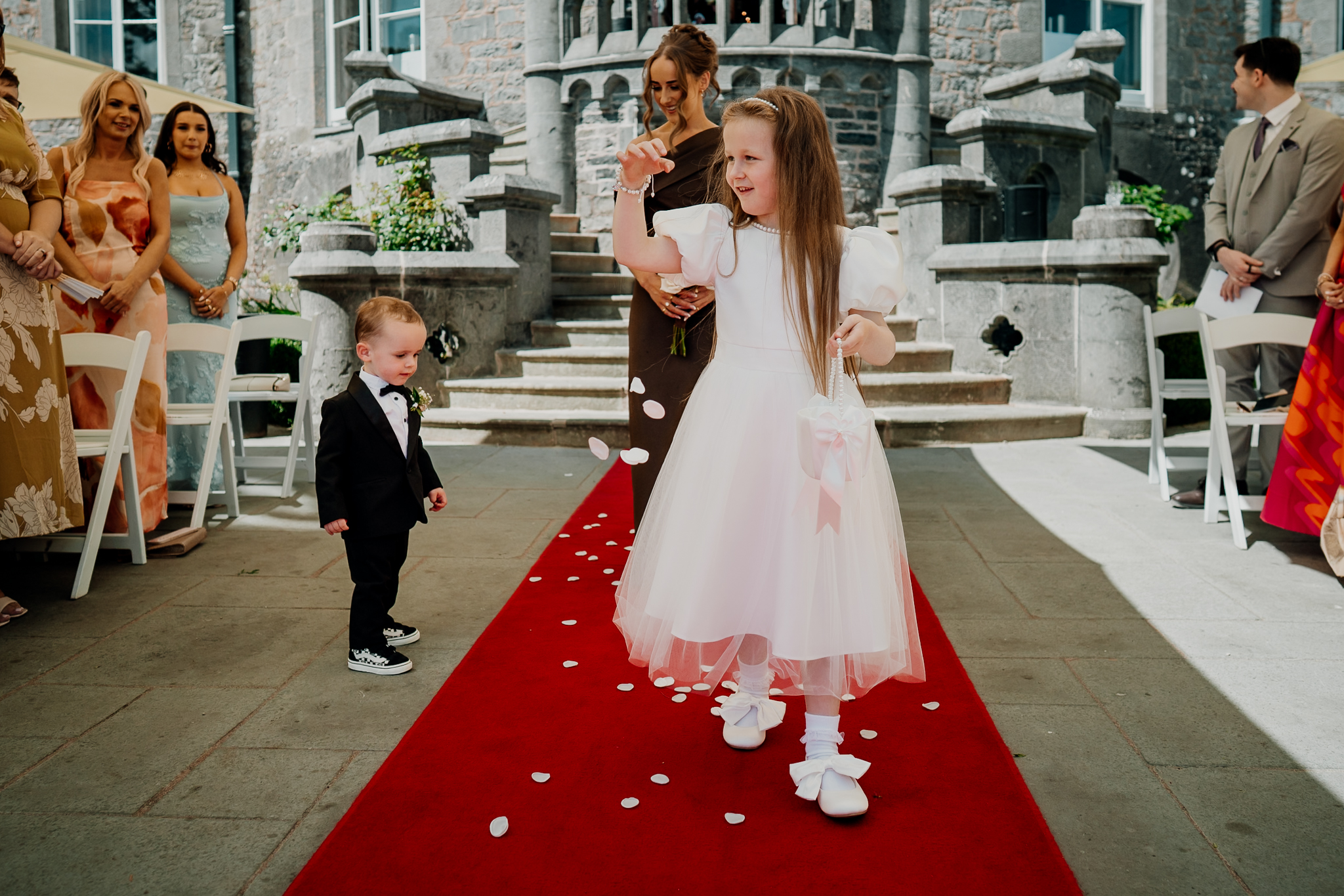 Bride Caoimhe with a young wedding guest during the outdoor ceremony at Markree Castle