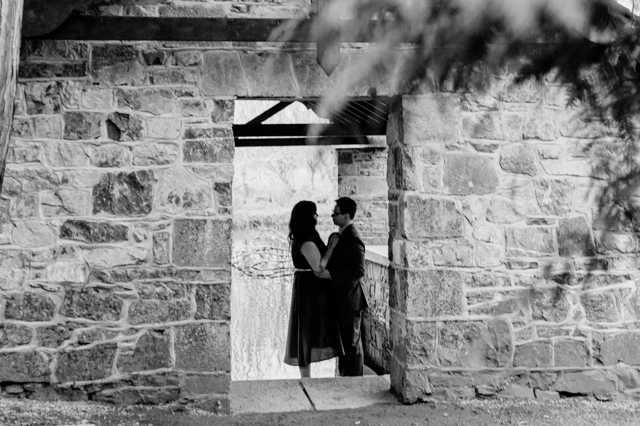 Black-and-white silhouette of a newly engaged couple kissing beside the stone boathouse at Markree Castle in County Sligo.
