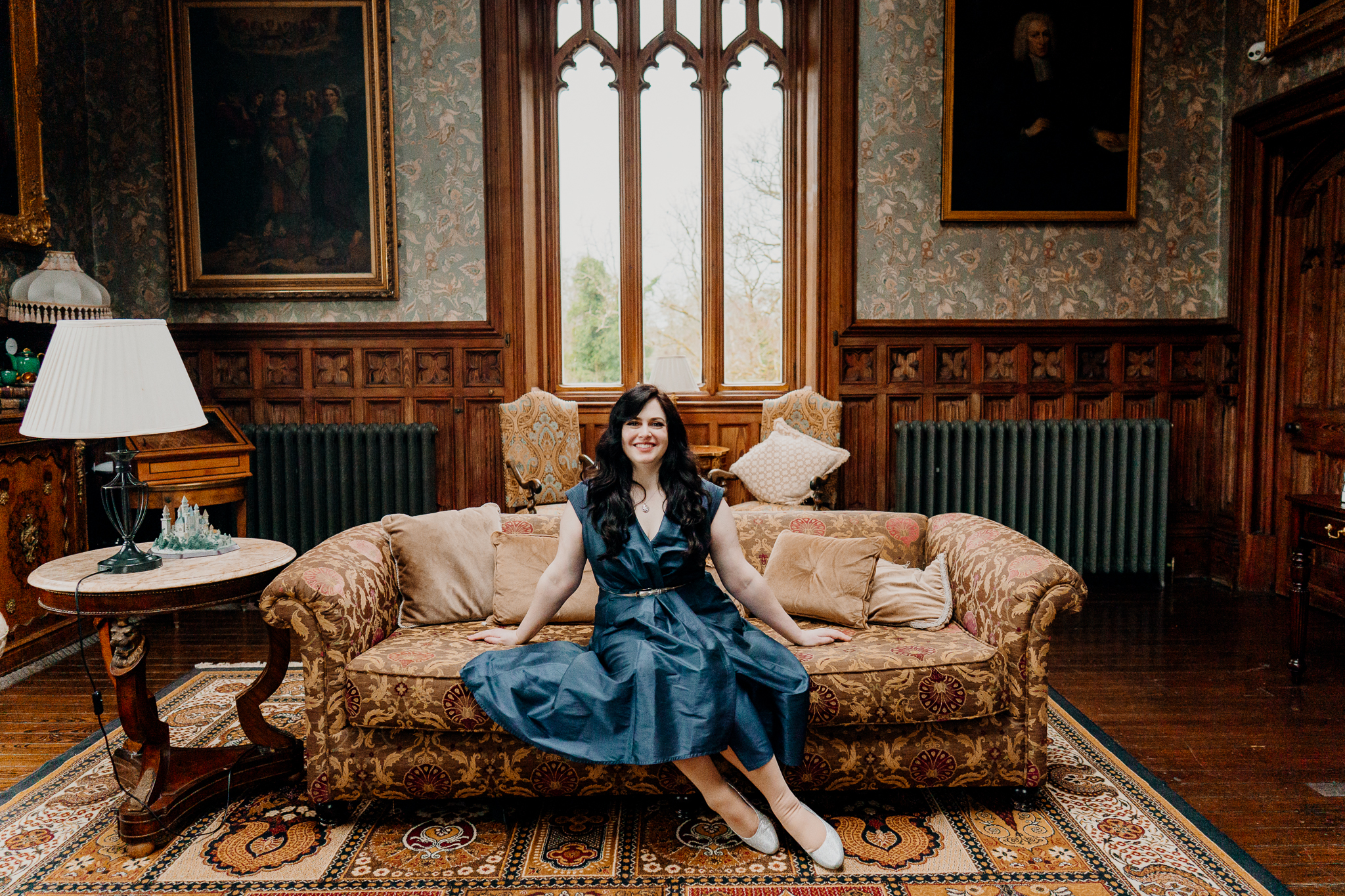 Portrait of a newly engaged woman relaxing on a sofa in the historic Billiard Room at Markree Castle in Sligo, Ireland.