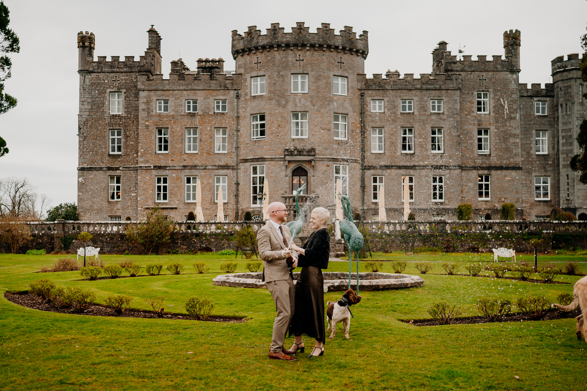Wedding couple posing in Markree Castle gardens with the historic castle facade behind them