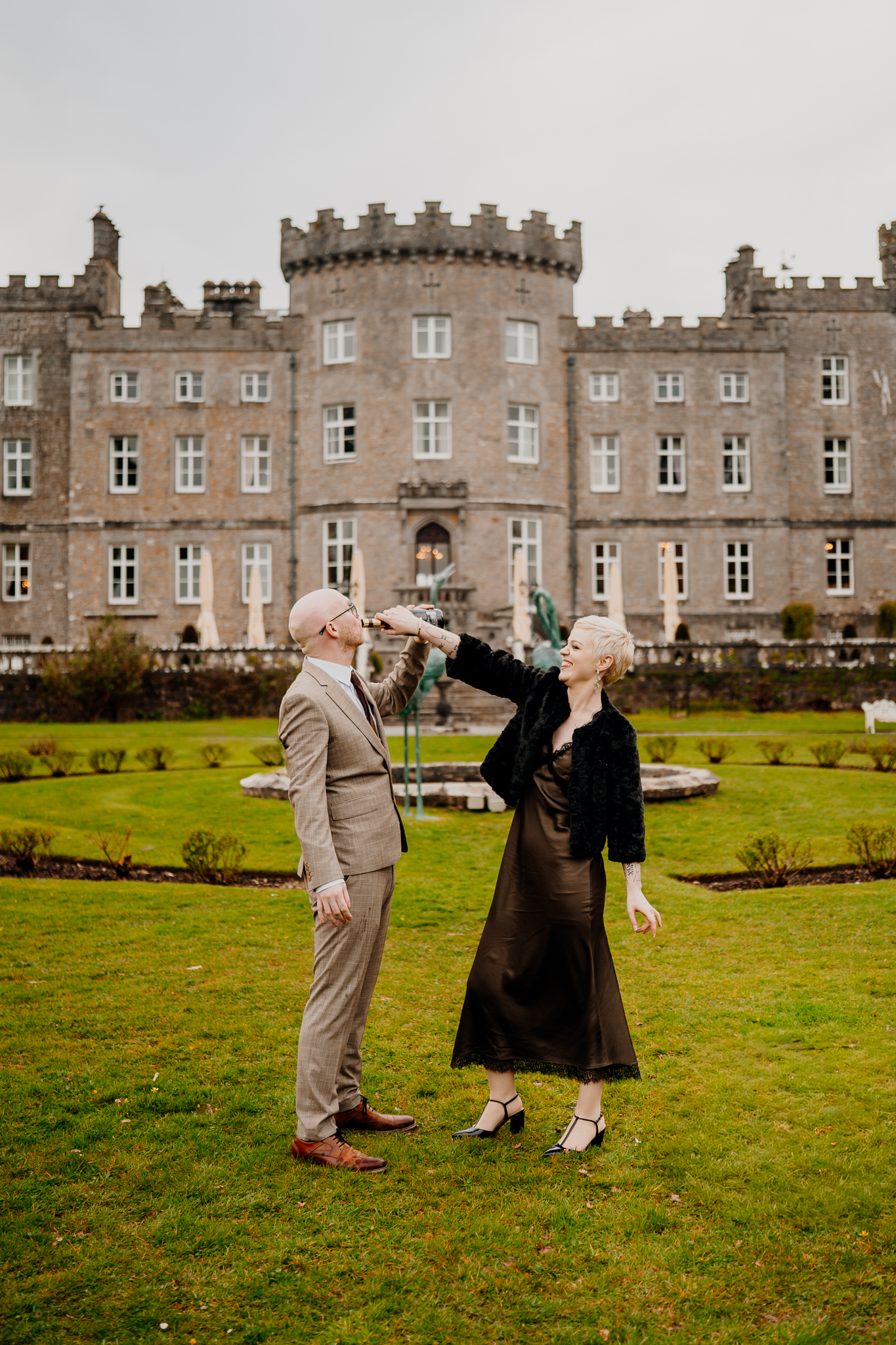 Joyful newlyweds celebrating in the gardens in front of Markree Castle Sligo