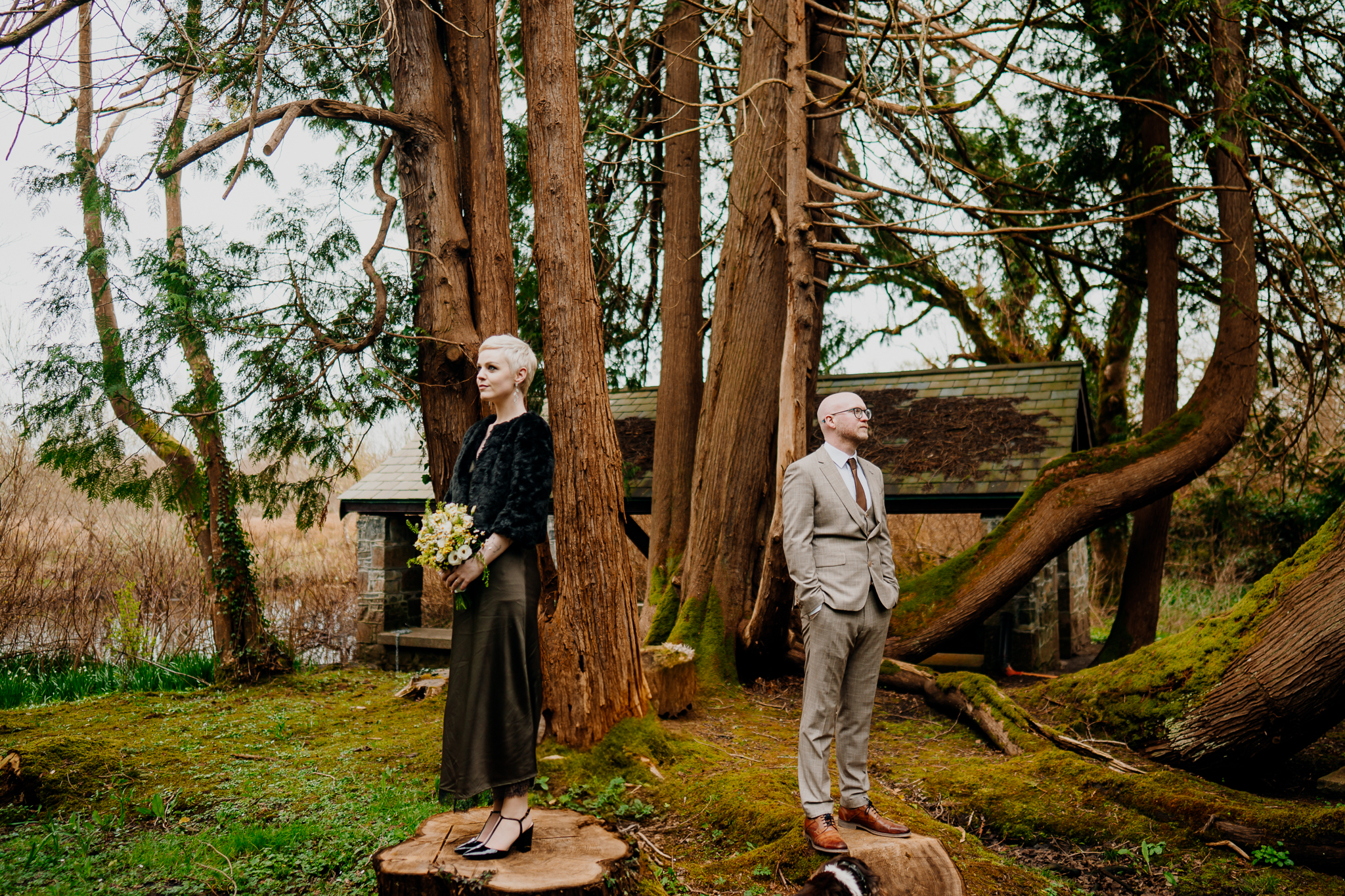 Wedding couple in the woodland at Markree Castle with the historic Boathouse behind them