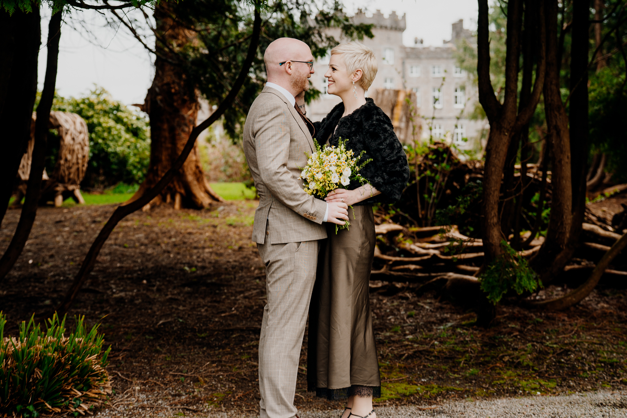 Intimate wedding couple embracing among mature trees in Markree Castle woodland
