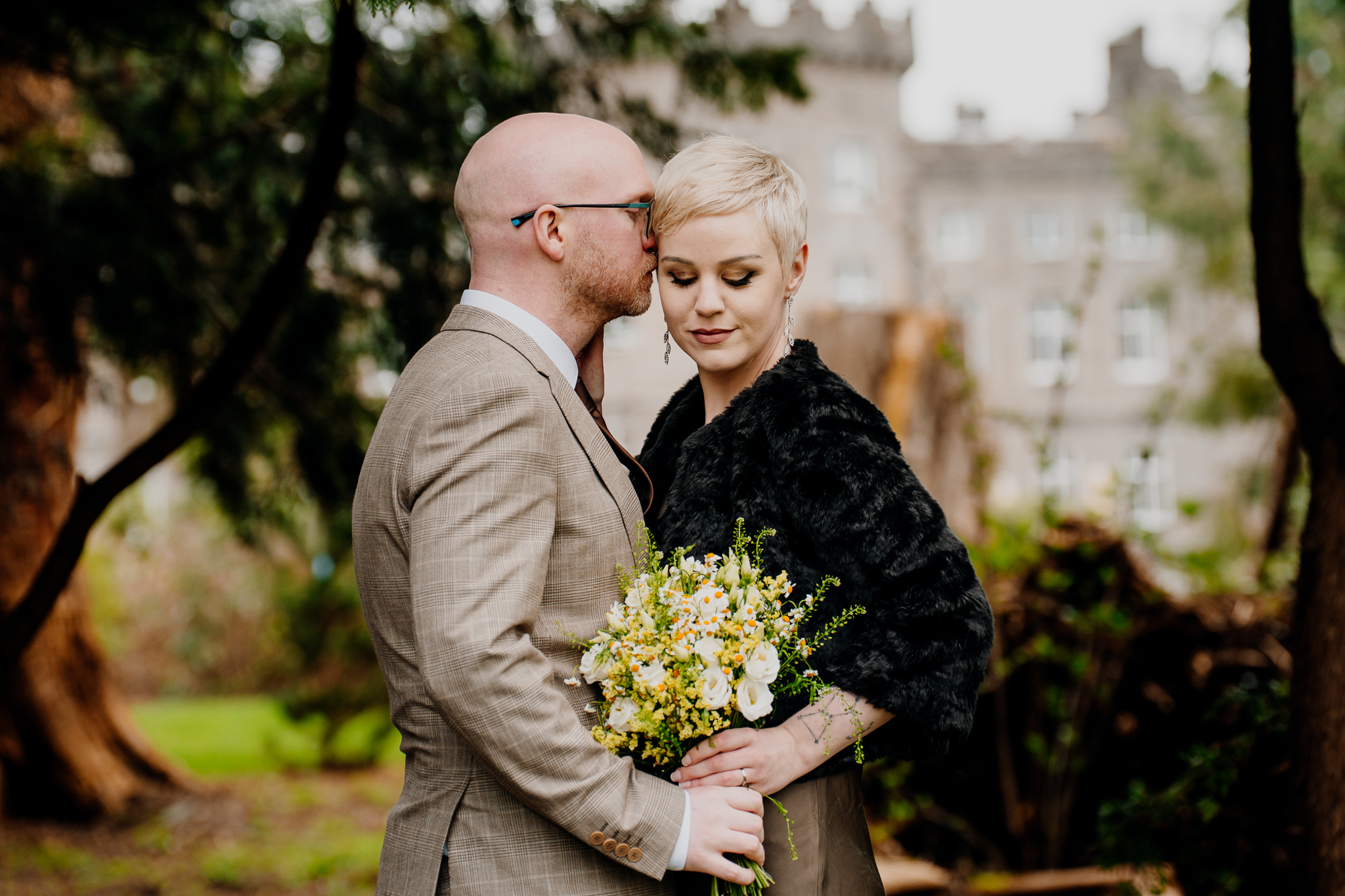 Newly married couple sharing a kiss in the woodland grounds of Markree Castle Sligo