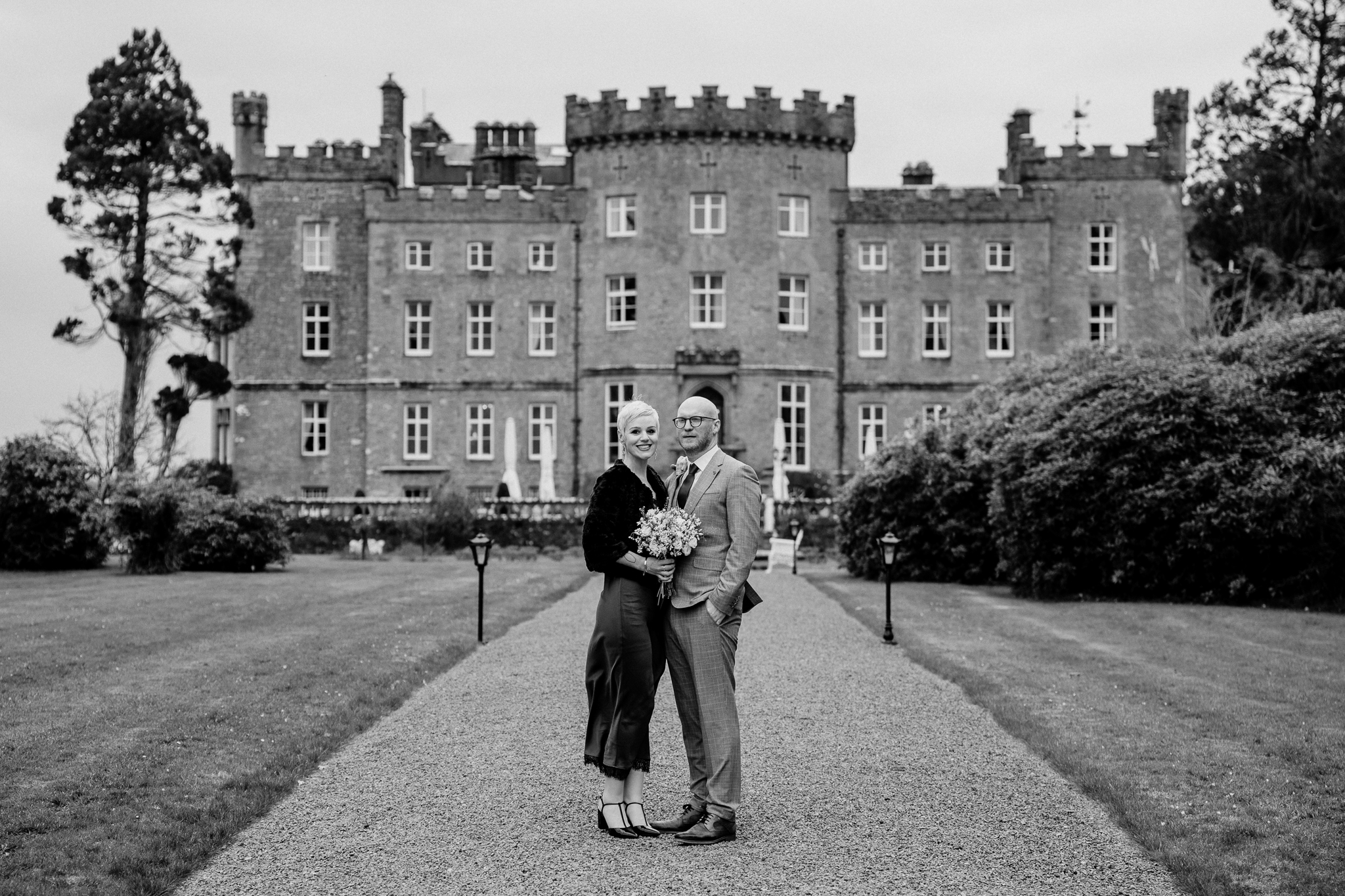 Intimate wedding couple standing together with the historic Markree Castle facade behind them