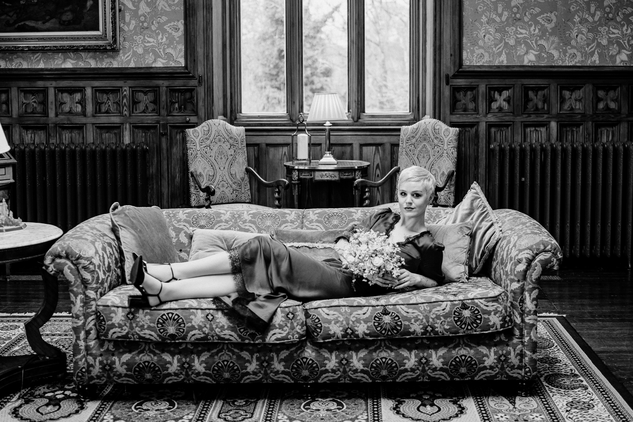 Black and white wedding portrait of newlyweds relaxing on a sofa in Markree Castle Billiard Room