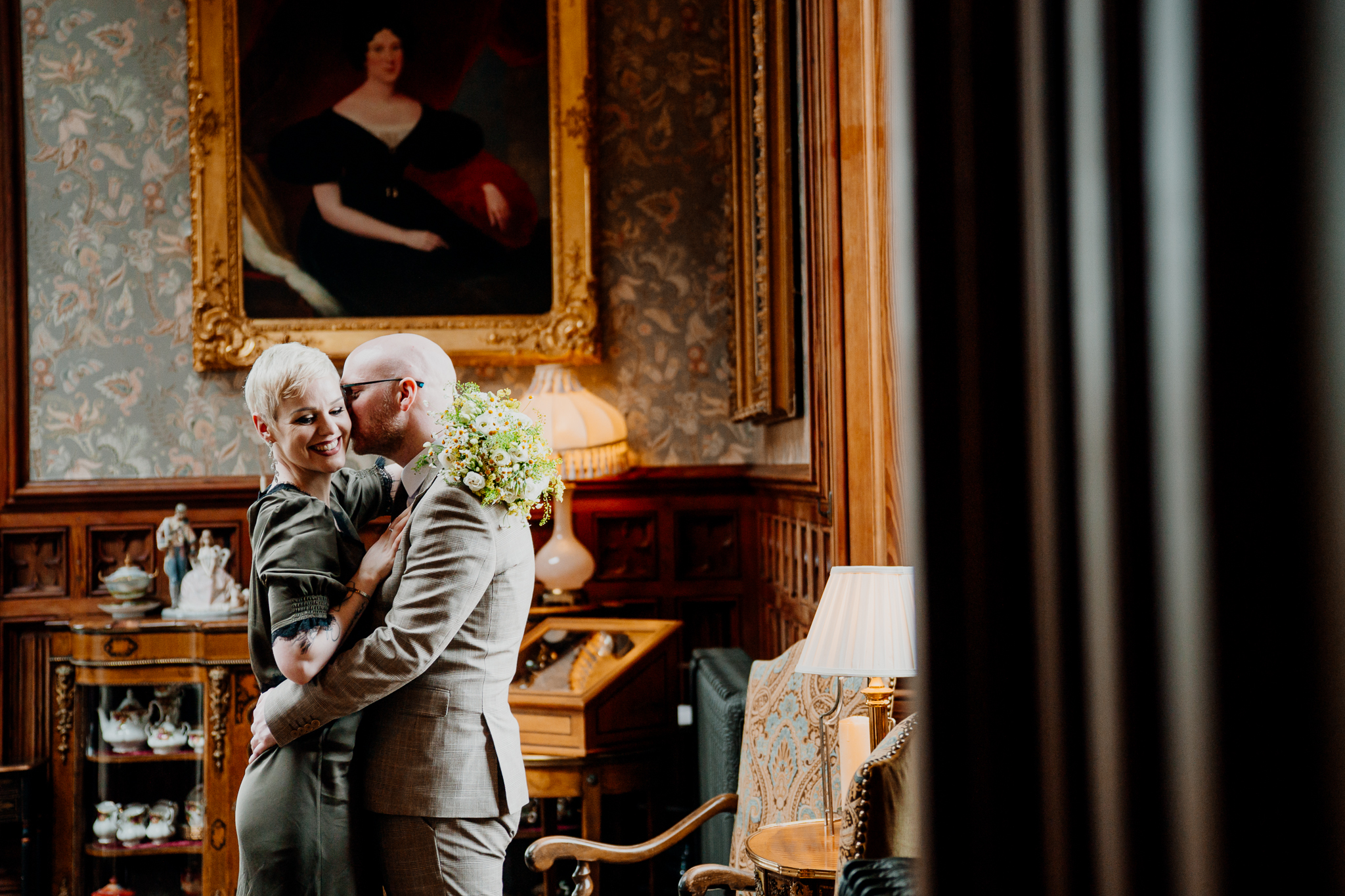 Newly married couple embracing beside the fireplace in Markree Castle Billiard Room