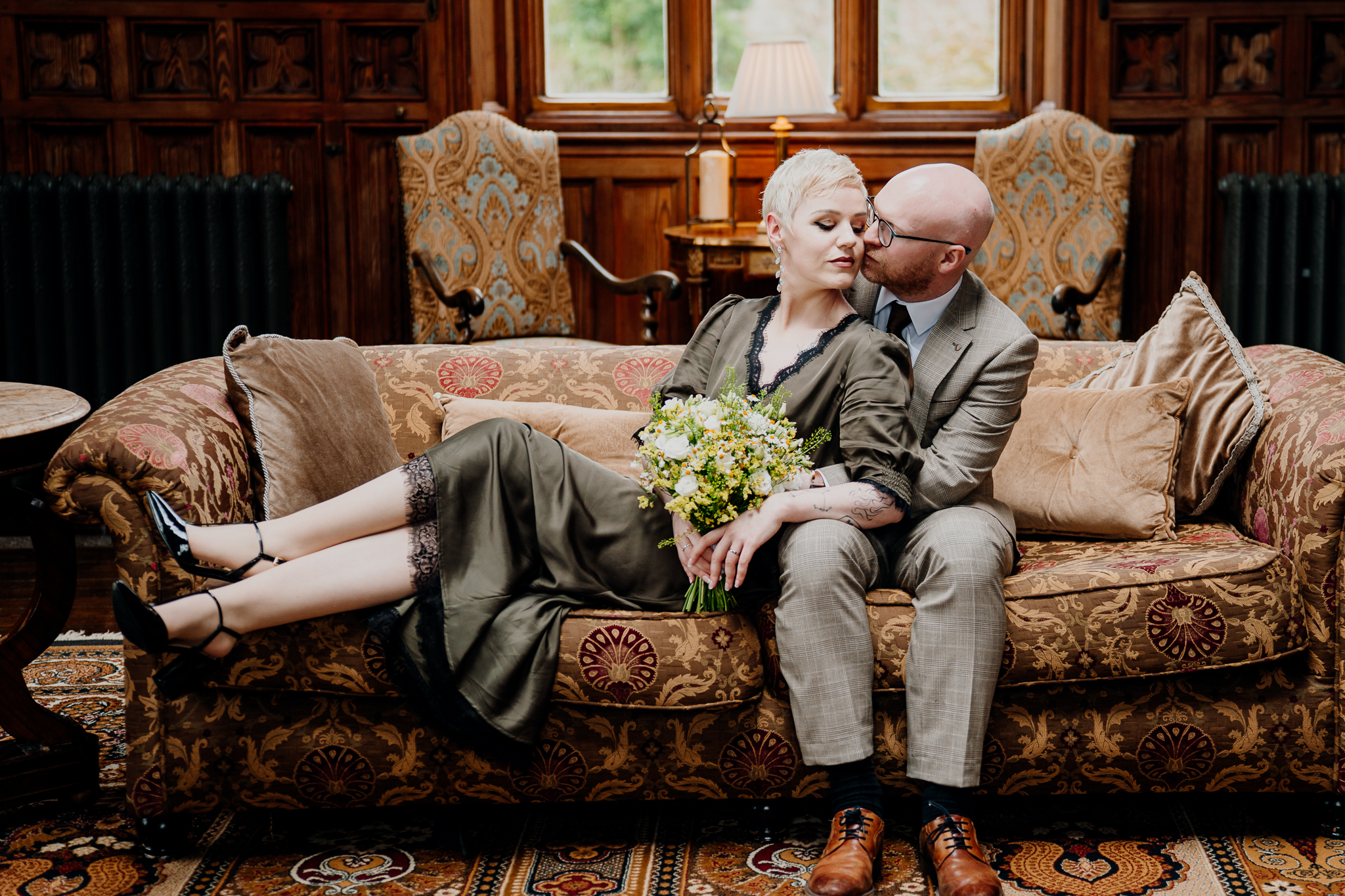 Newlyweds relaxing together on an antique sofa inside Markree Castle Billiard Room