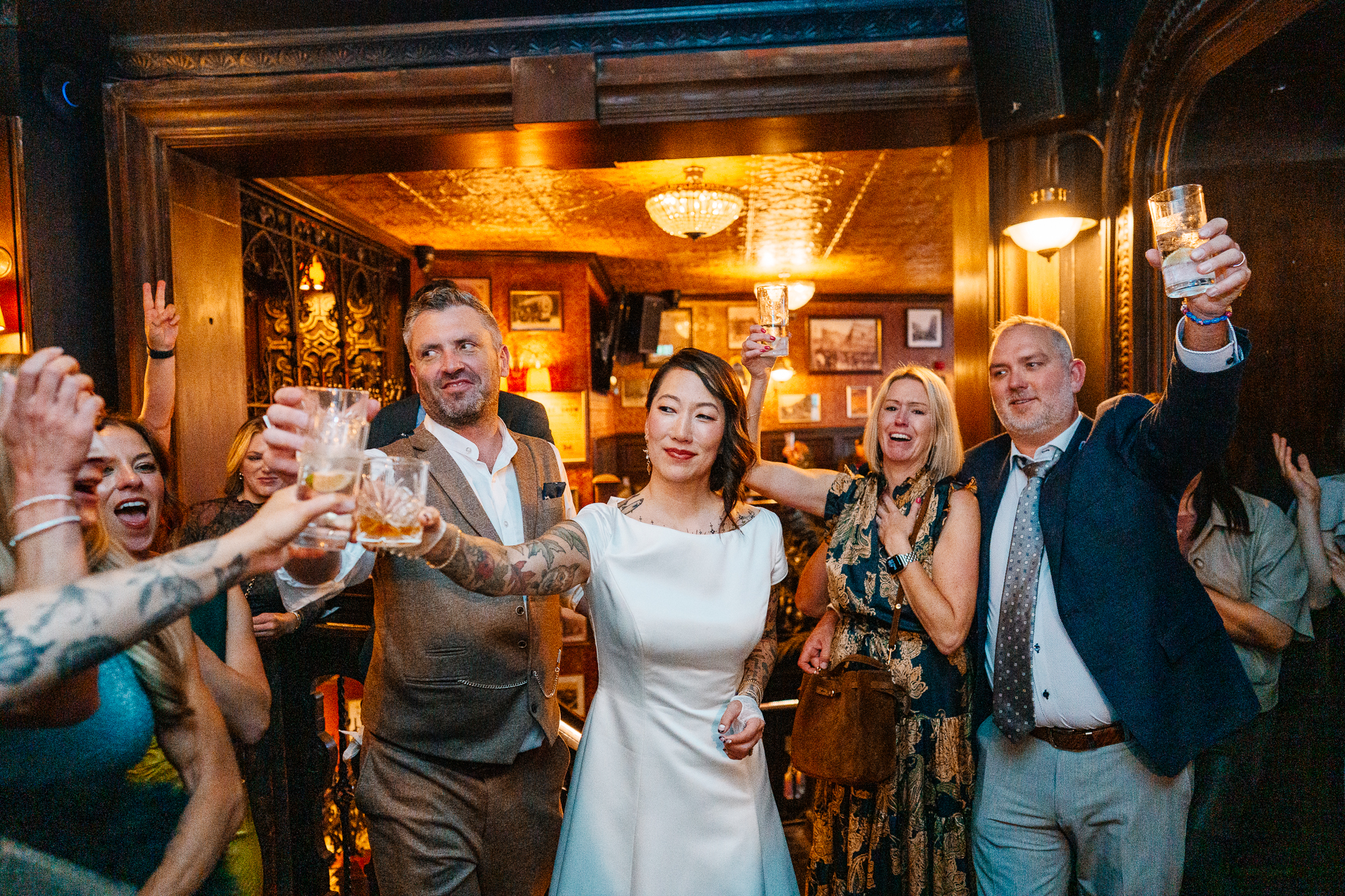 Group of smiling wedding guests seated together at a table inside J.R. Mahon's Dublin