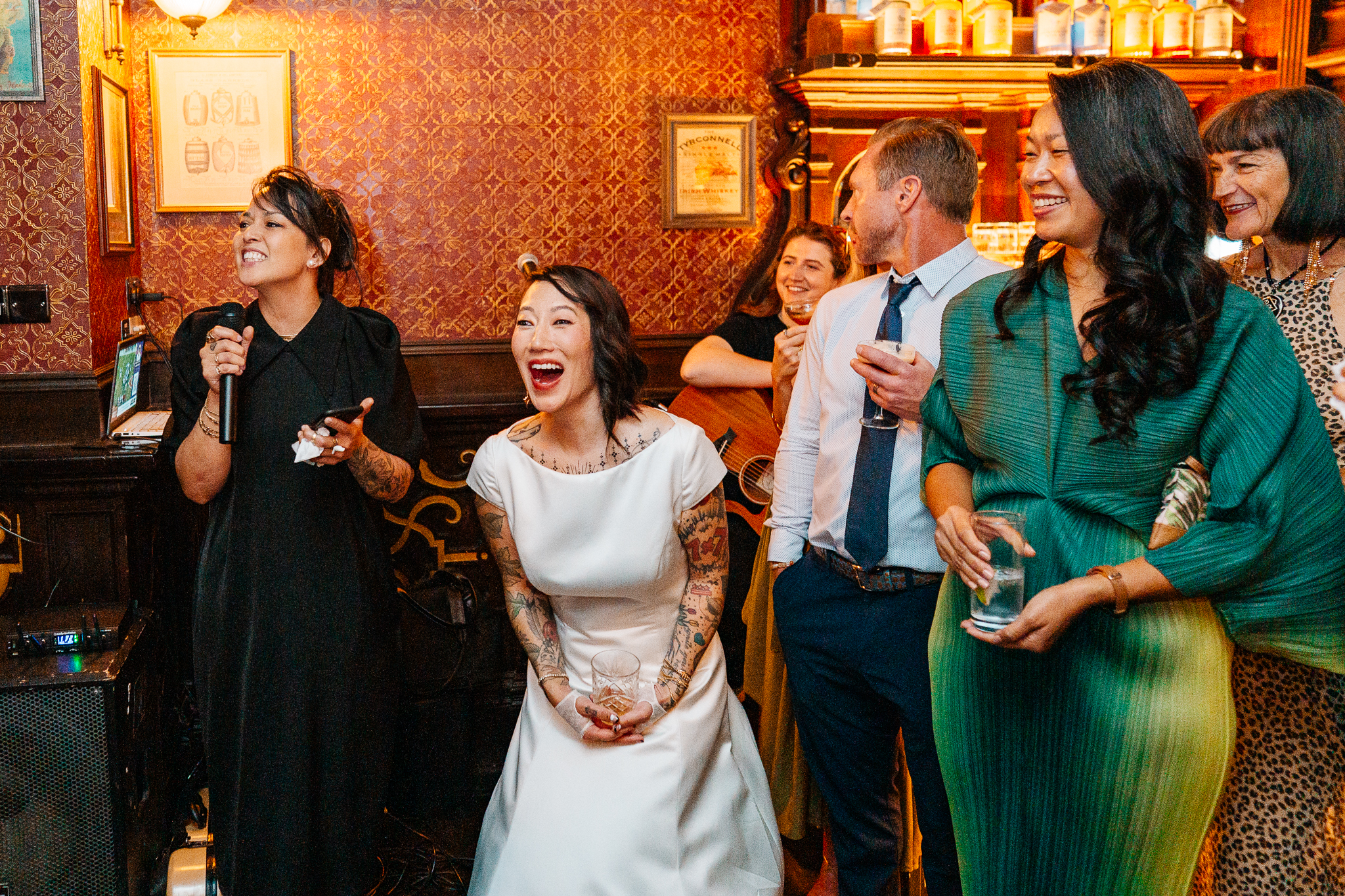 Wedding guests laughing and reacting during a lively celebration at J.R. Mahon's Dublin