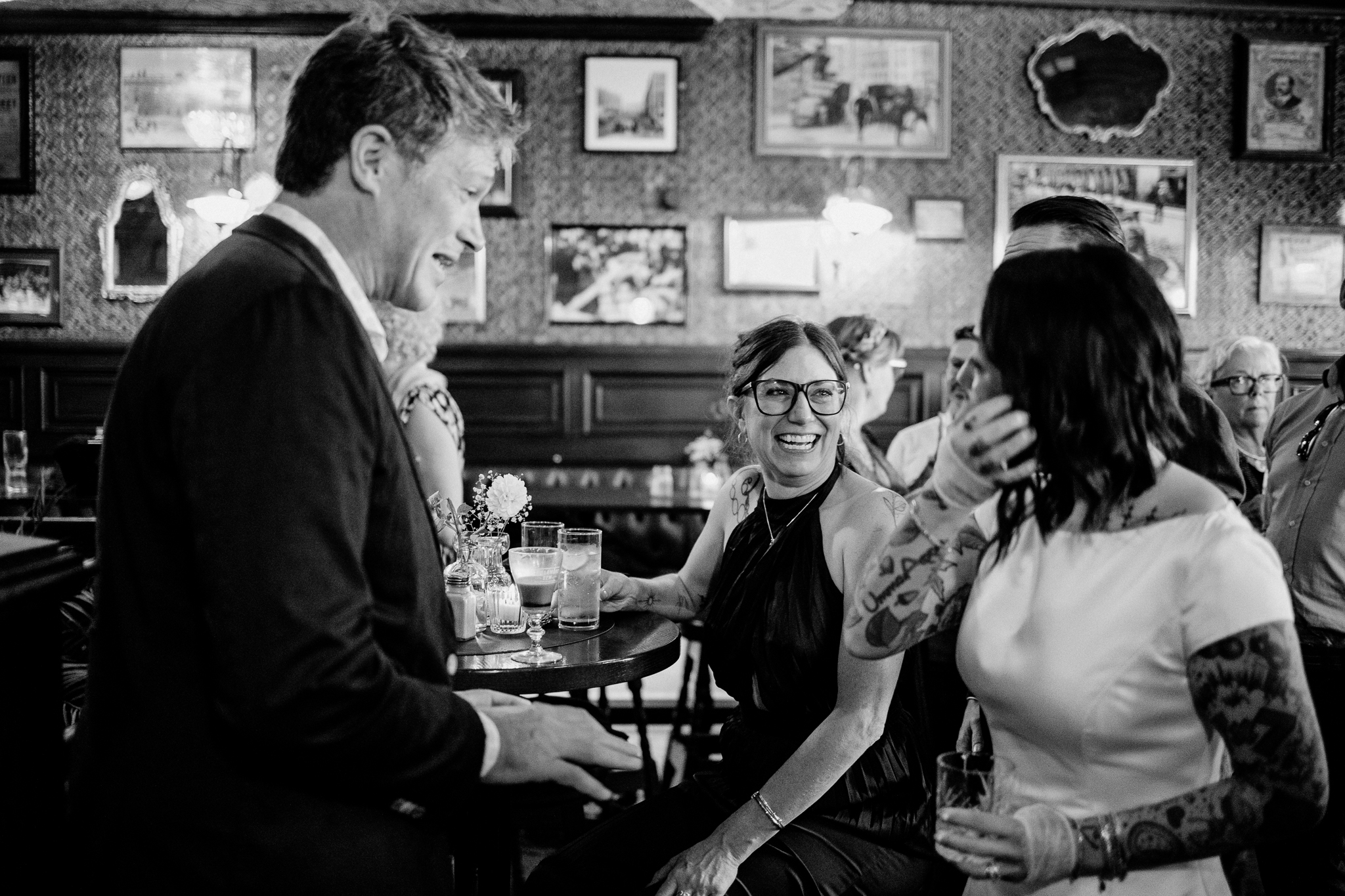 Man in a suit speaking with a seated female guest during a wedding reception at J.R. Mahon's Dublin