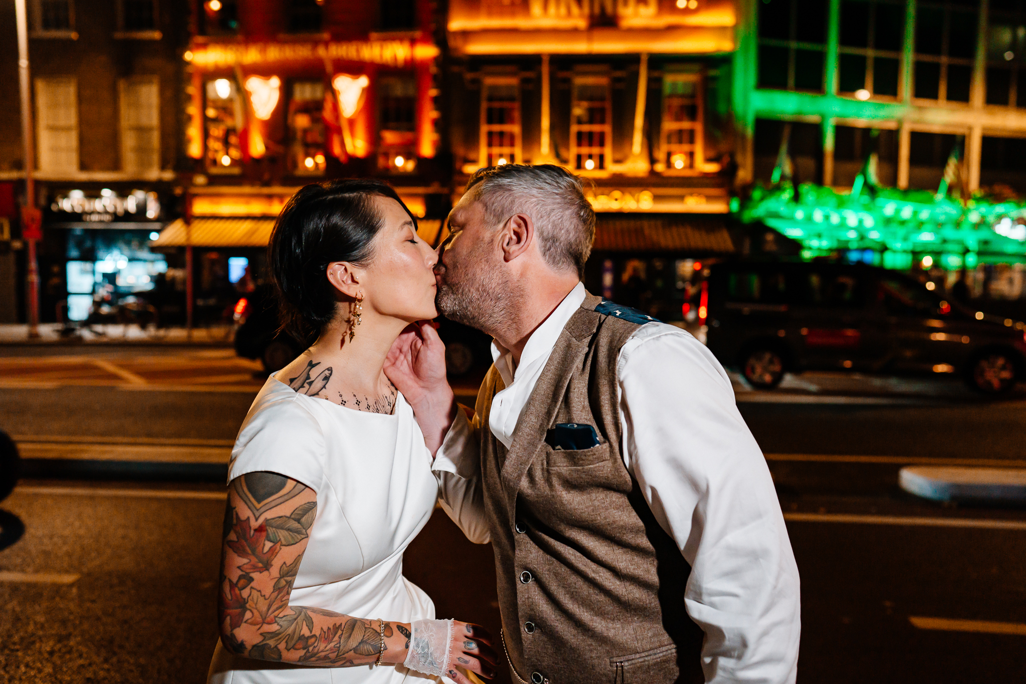 Bride and groom kissing inside the warmly lit J.R. Mahon's pub during their Dublin wedding evening