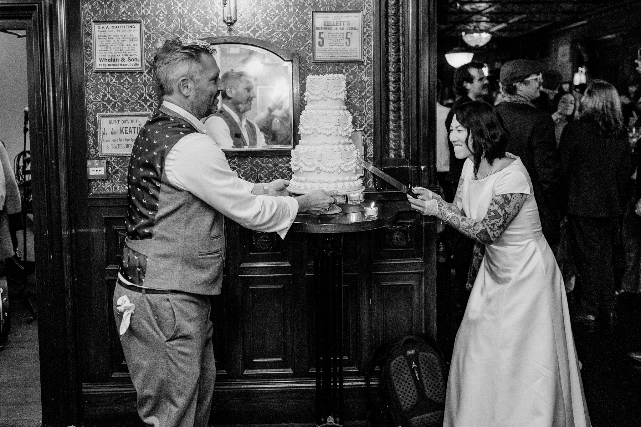 Black and white candid photograph of the bride and groom during their wedding cake cutting at J.R. Mahon's Dublin