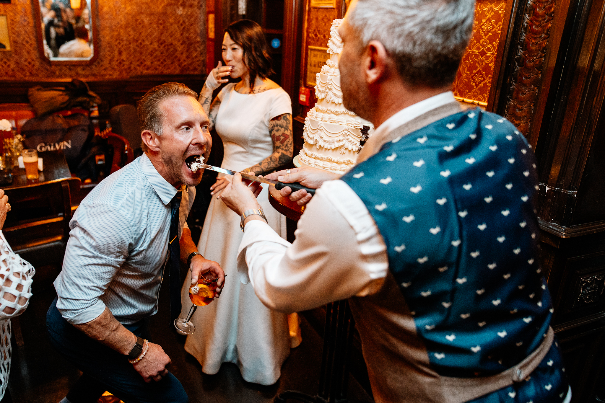 Bride and groom cutting their wedding cake as guests watch inside J.R. Mahon's pub in Dublin