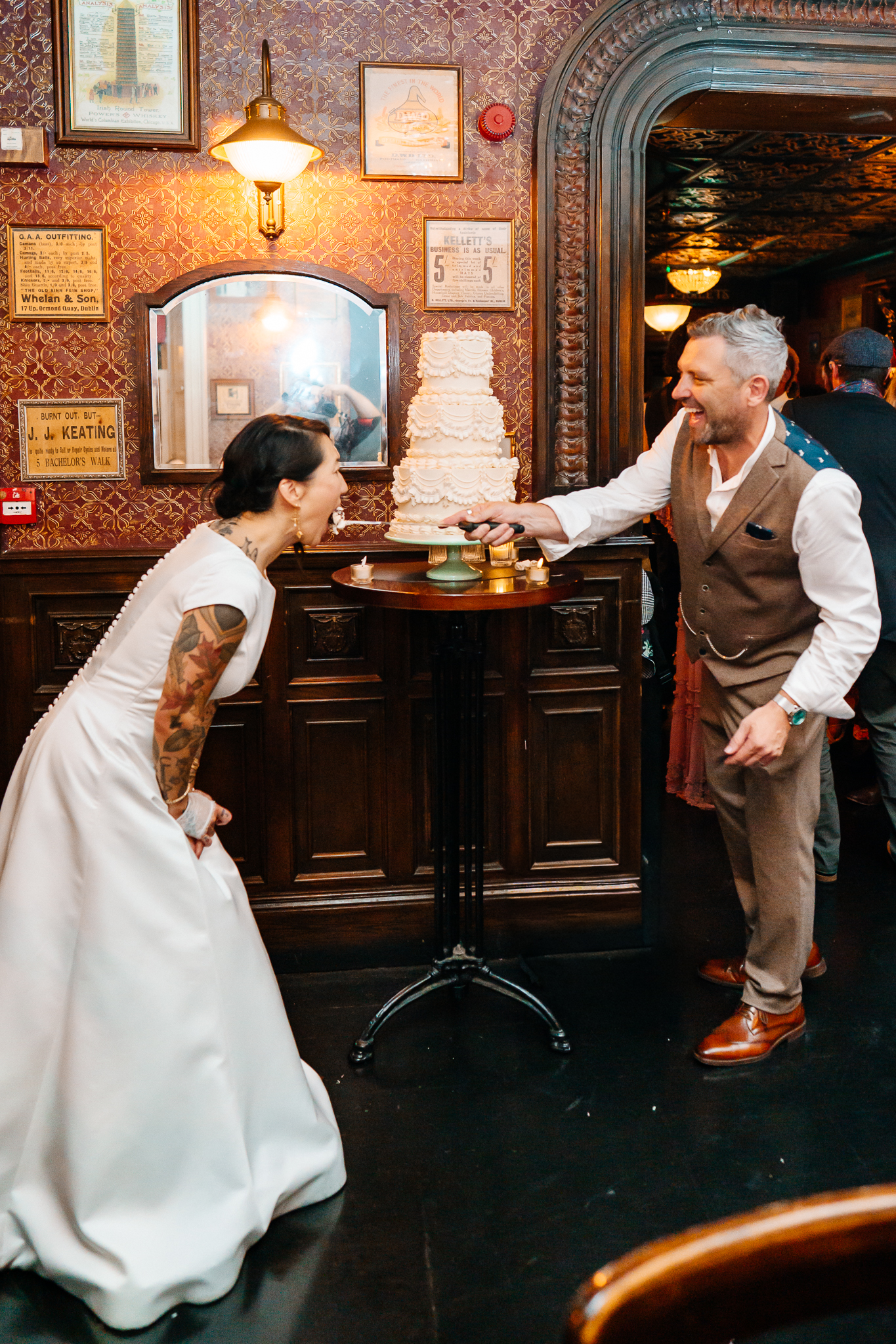 Bride and groom cutting their wedding cake together inside J.R. Mahon's pub in Dublin