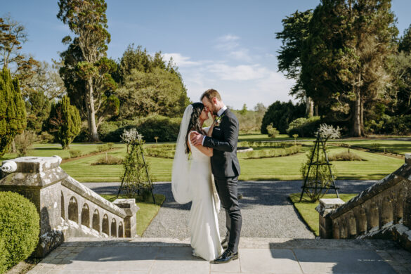 Bride and groom posing together on the stone steps in the gardens of Markree Castle, Sligo, Ireland.
