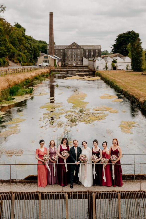 Bride and bridesmaids posing beside the reflecting pond at The Millhouse wedding venue in Slane, County Meath, Ireland.