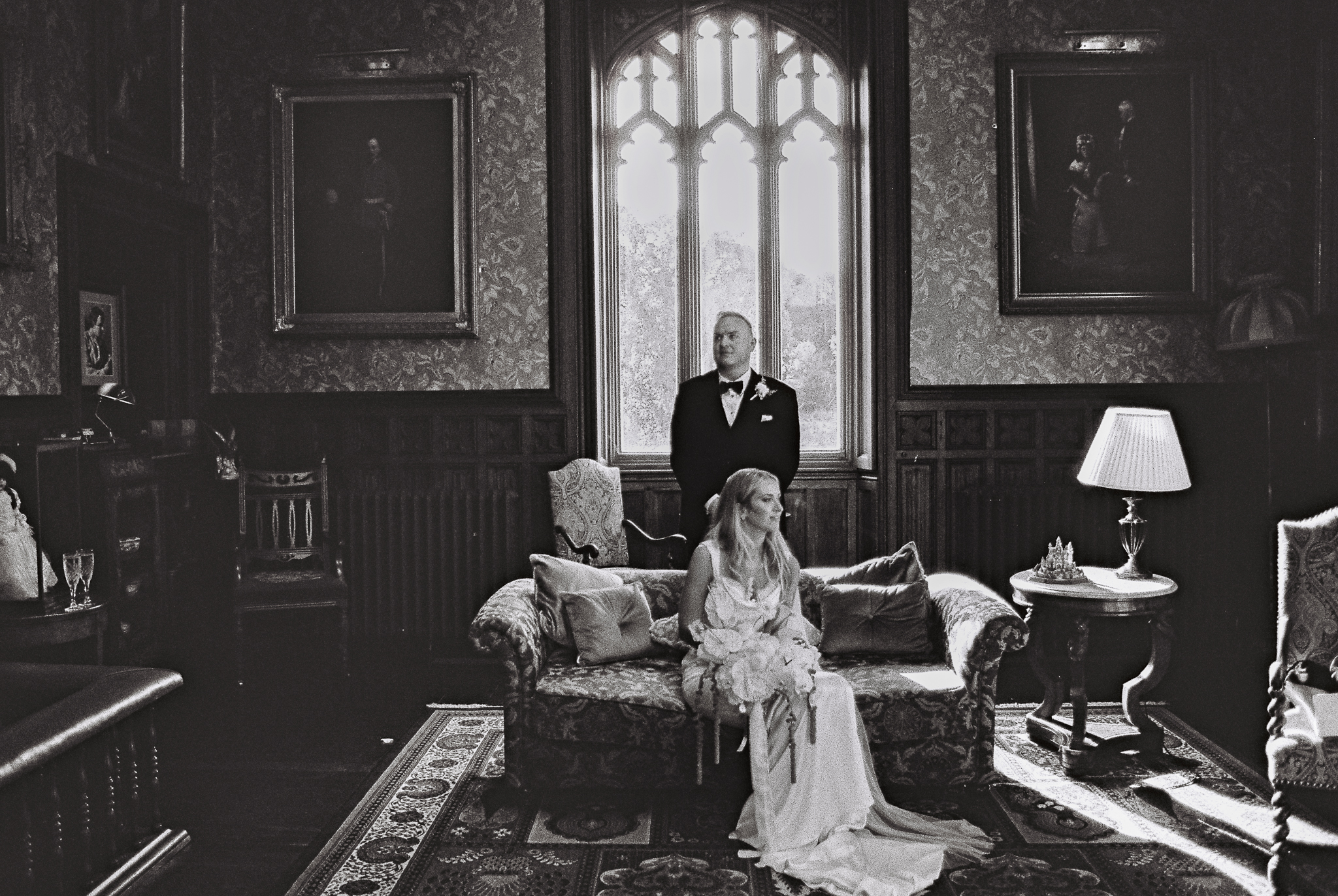 Black and white 35mm film wedding portrait of a bride seated beside the groom in an elegant historic room at Markree Castle, County Sligo, Ireland.