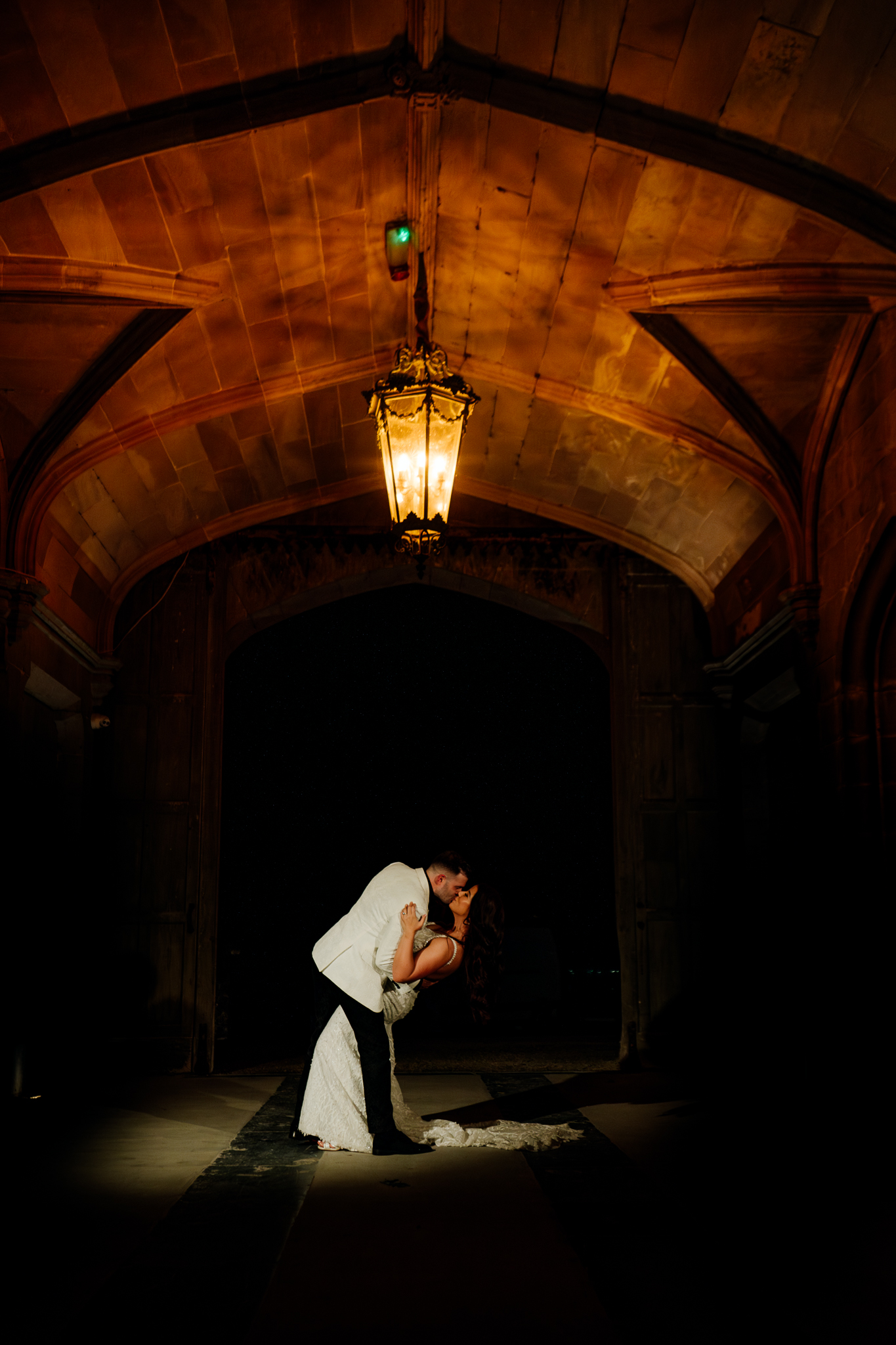 Warmly illuminated stone archway at the entrance to Markree Castle at night.