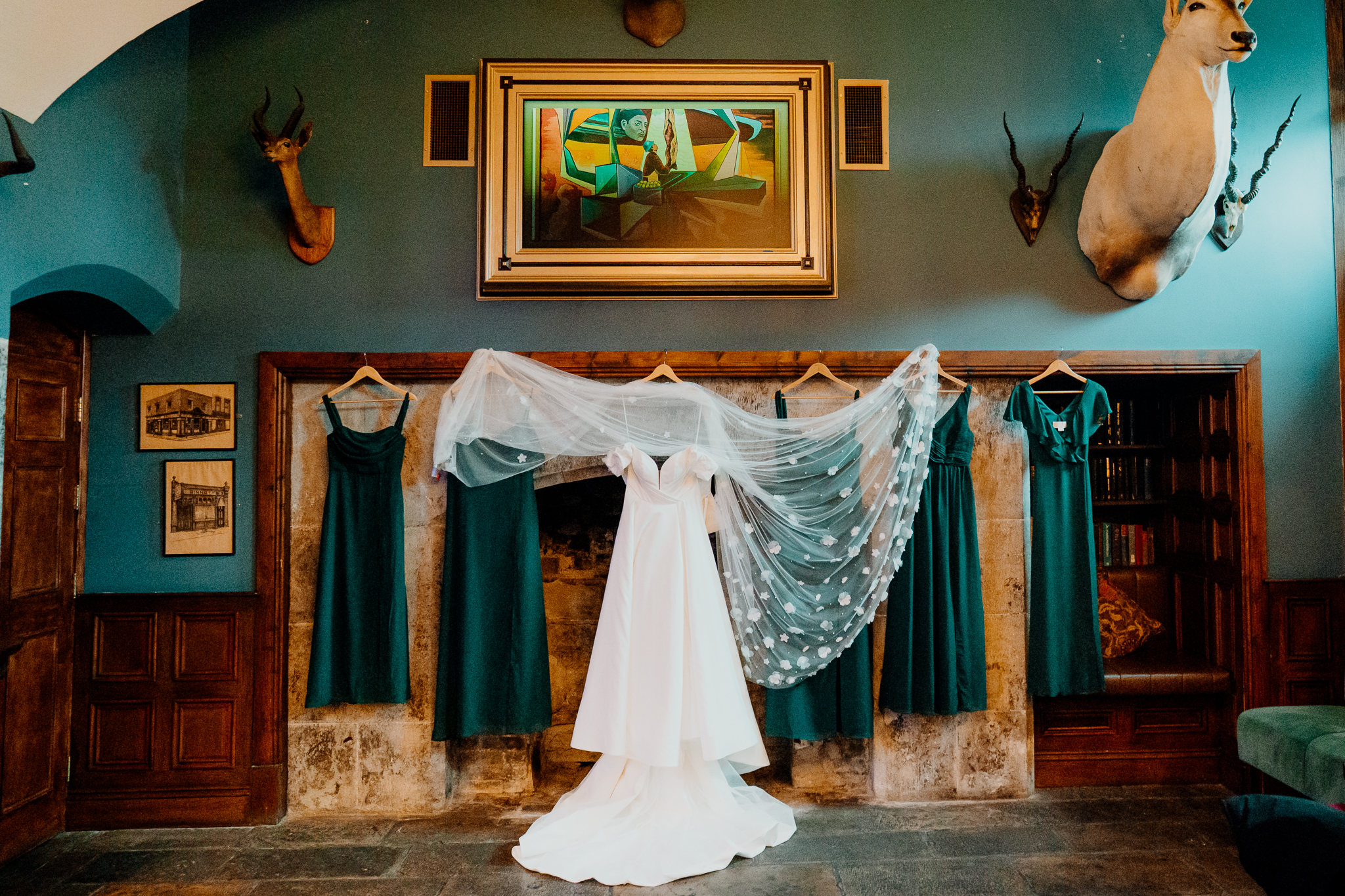 Wedding dress and bridesmaid dresses hanging in the Gin Bar at Markree Castle before the wedding ceremony.