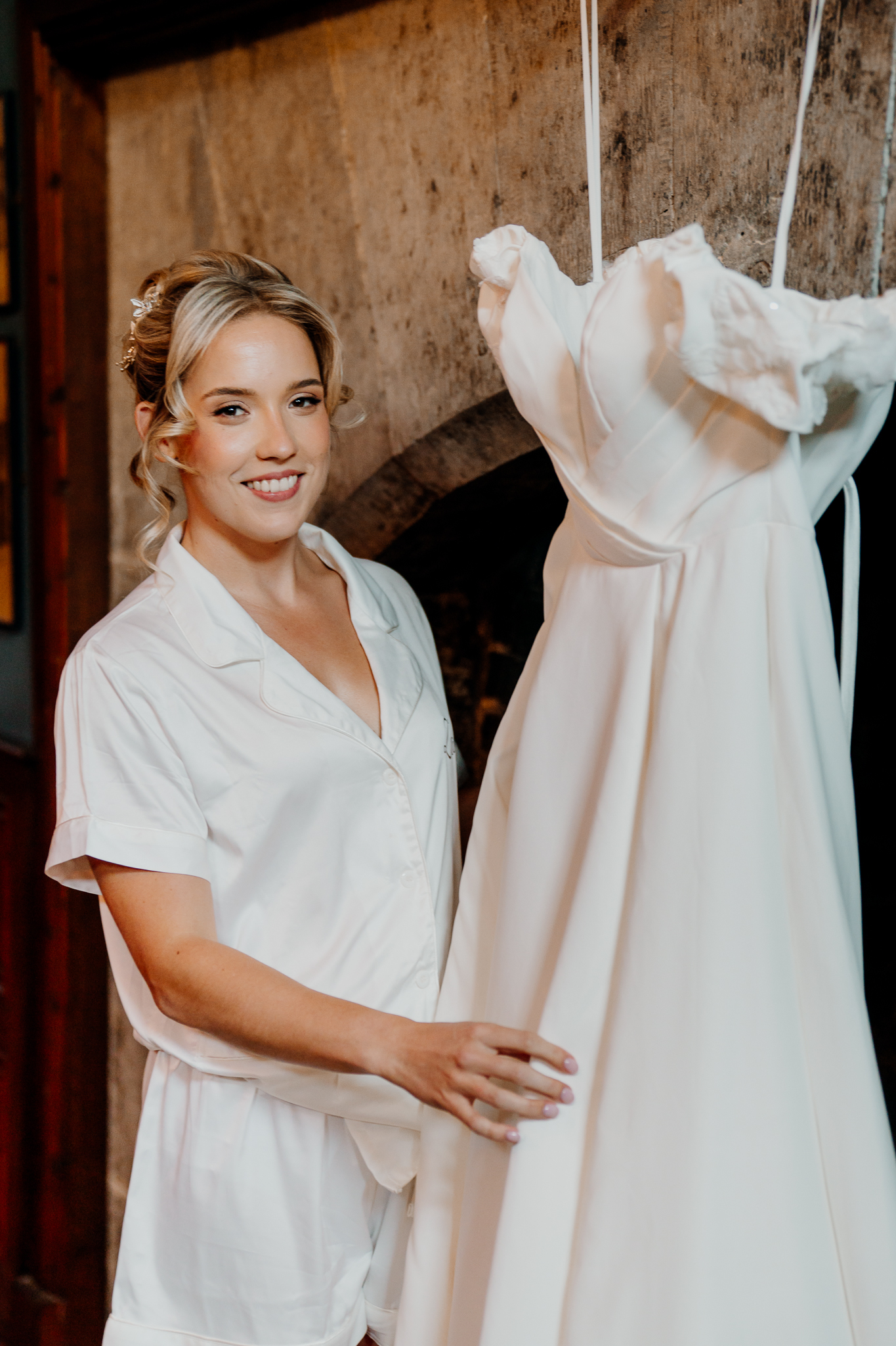 Bride smiling beside her hanging wedding dress in the Gin Bar at Markree Castle before the ceremony.