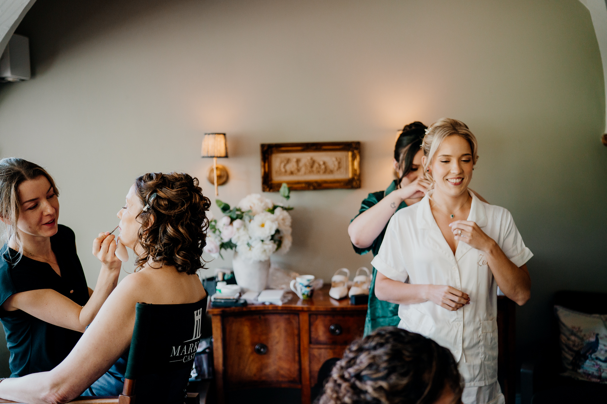 Bride having her makeup applied during wedding morning preparations in the Butler's Kitchen at Markree Castle.