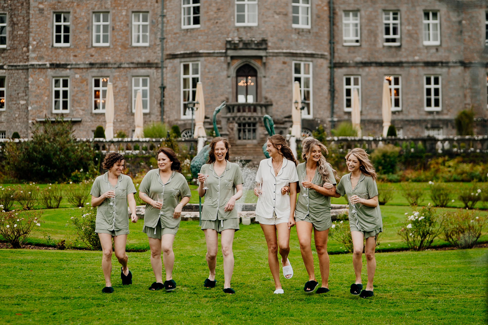 Bride and bridesmaids posing together in the gardens in front of the historic facade of Markree Castle, Sligo.